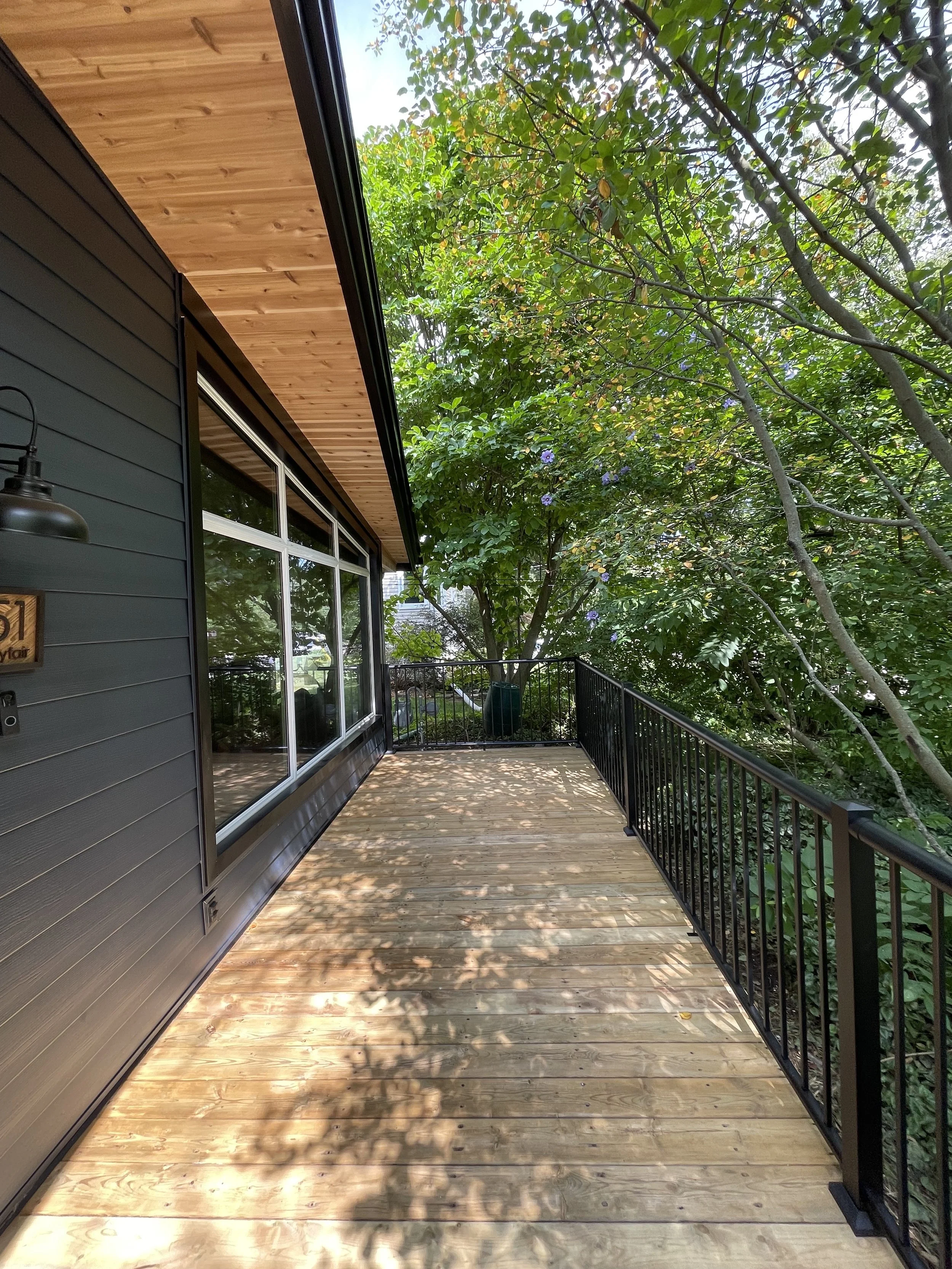 modern-wood-balcony-black-aluminum-railing-forest-view