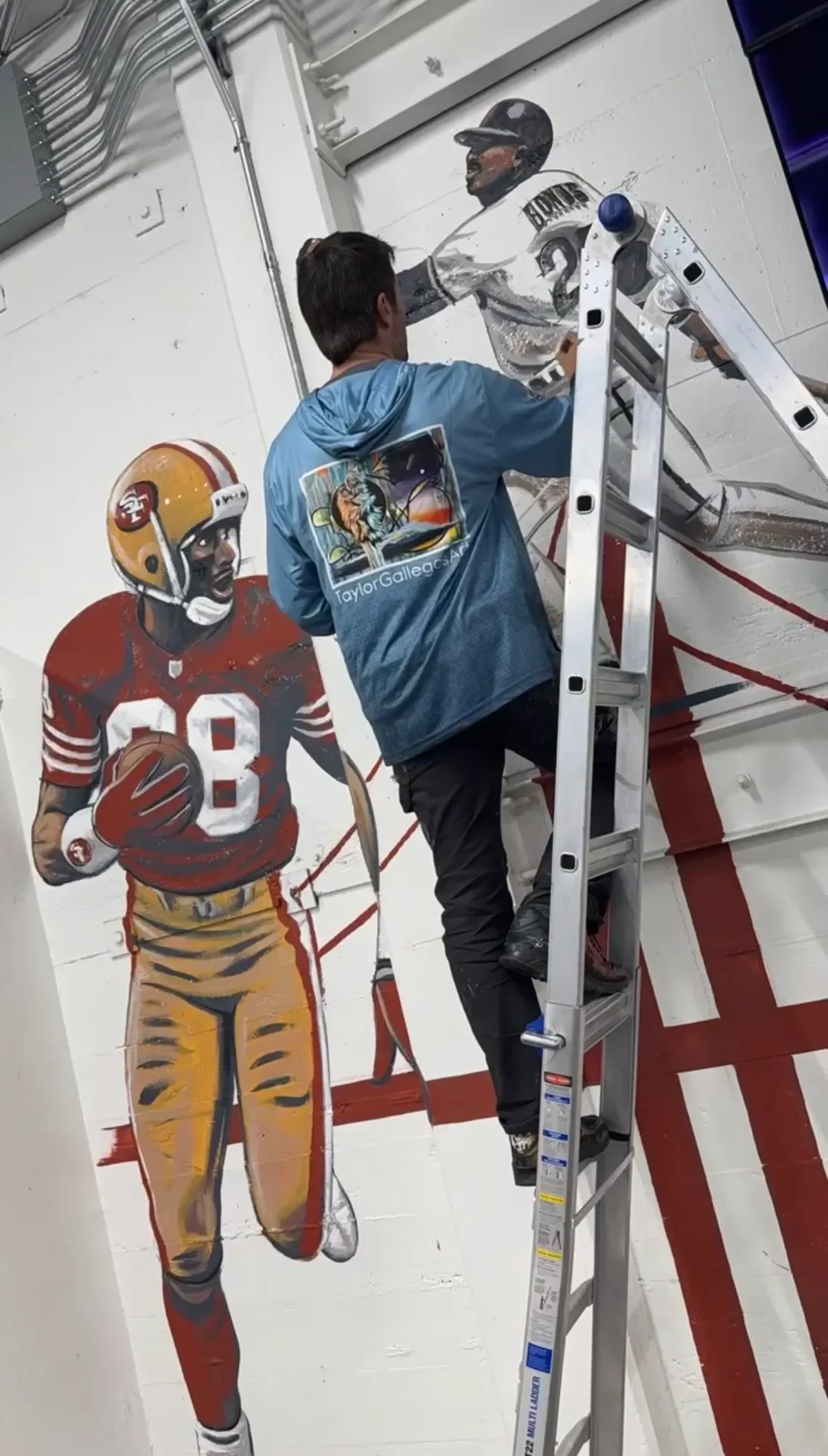 Muralist Taylor Gallegos painting San Francisco 49ers sports mural in progress