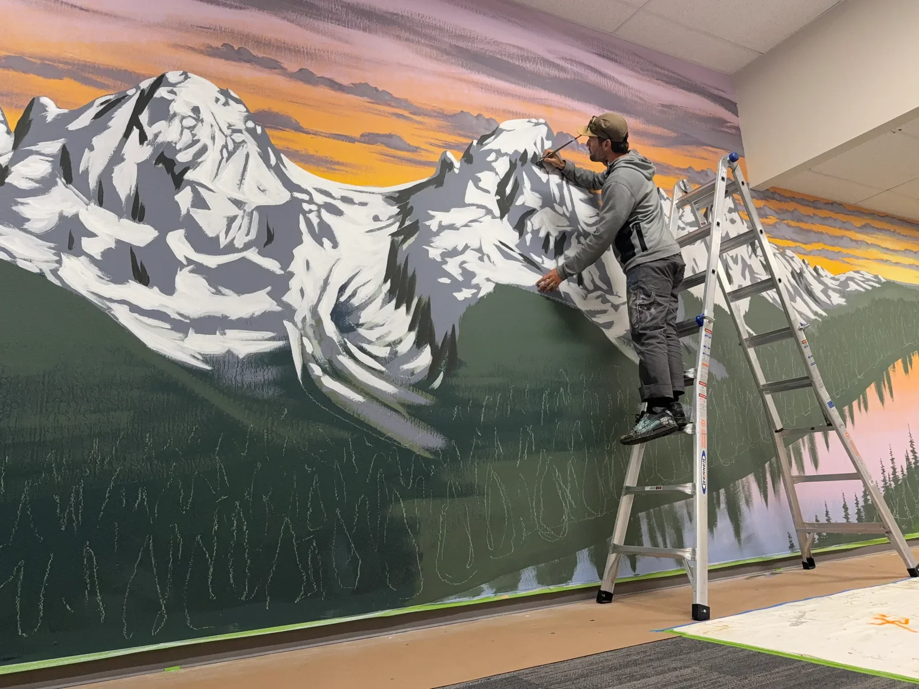 Muralist Taylor Gallegos painting large-scale custom mural in progress at Muon Space, San Jose, CA