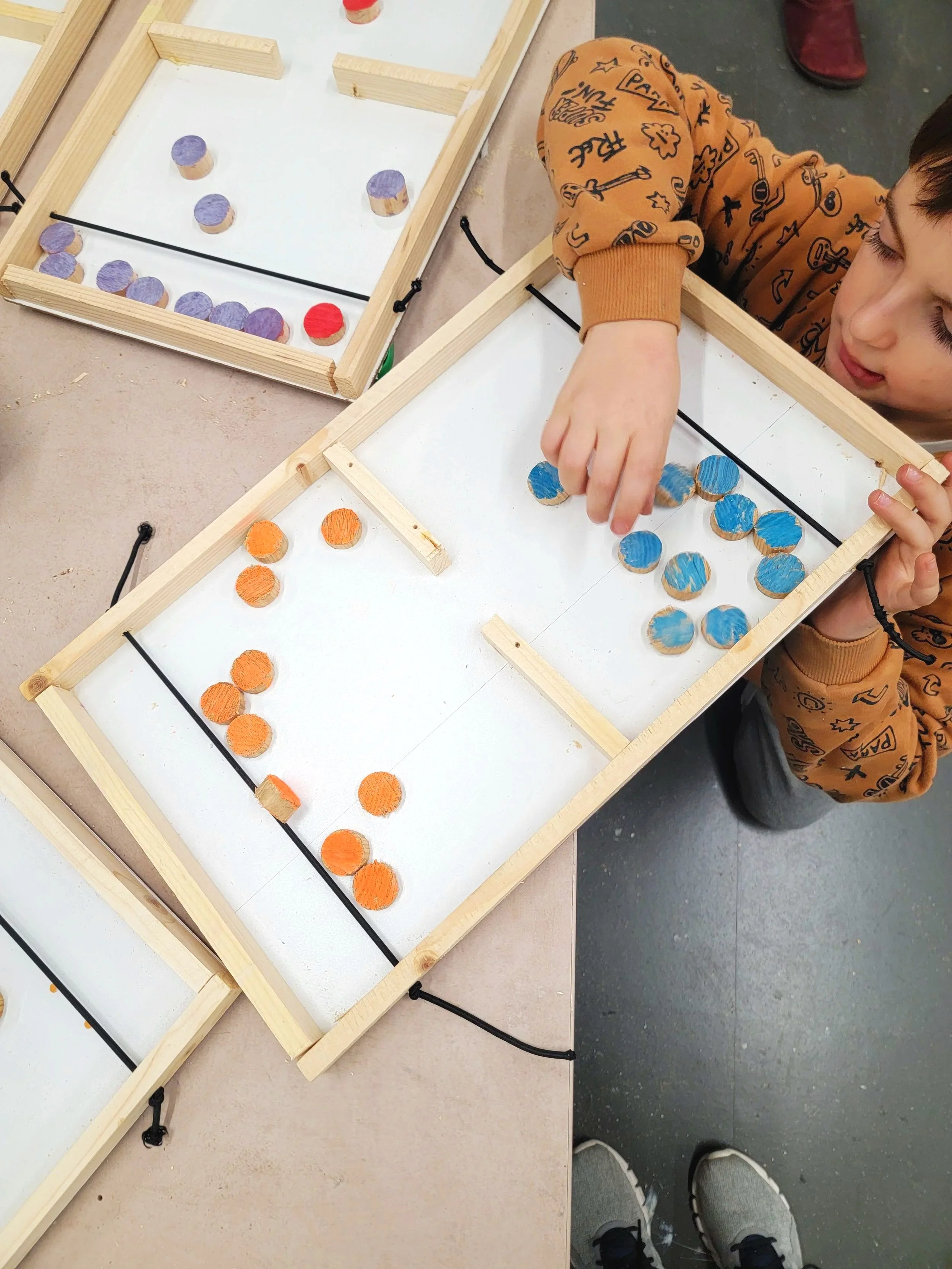 Photo d'un jeu de palet en bois fabriqué par un enfant pendant un atelier de menuiserie pour enfants.