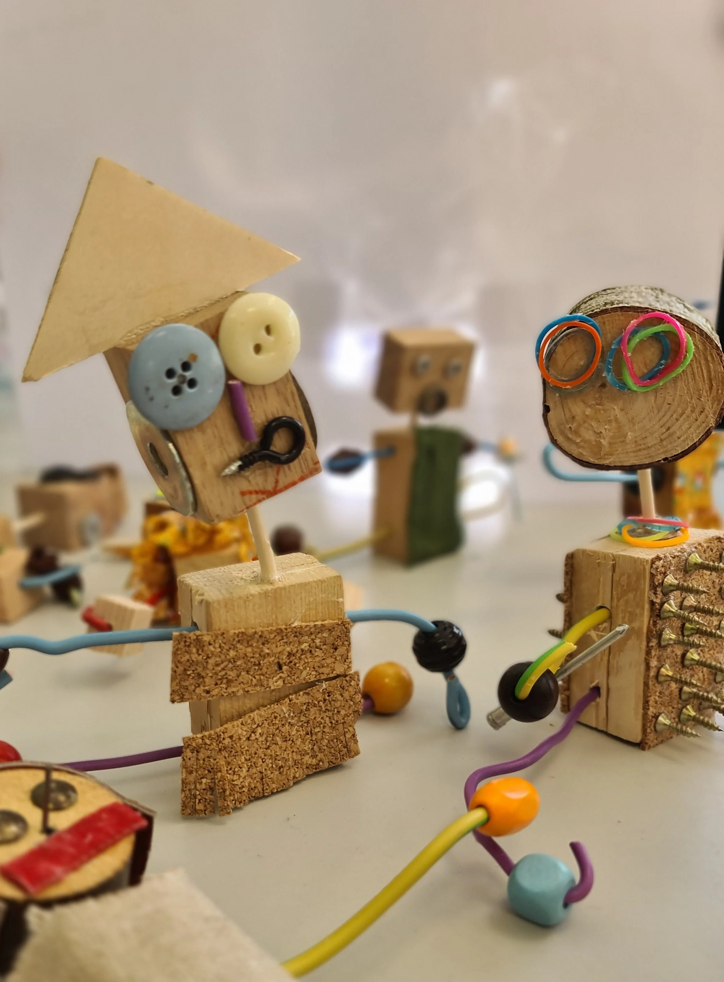 Photo de petits robots ou personnage en bois fabriqués par les enfants avec des clous, des boutons et des fils de fers