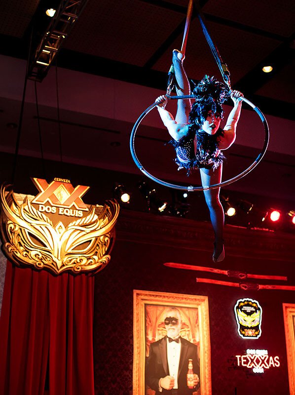 Aerial performer suspended in a hoop, entertaining guests at an indoor event.