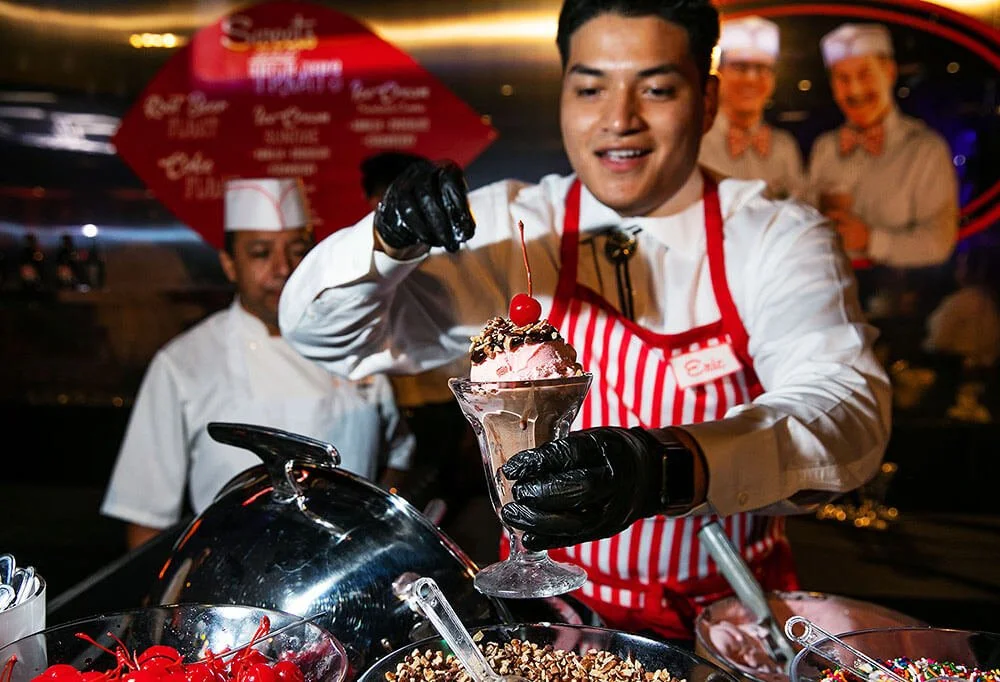 Chef carefully preparing a dessert, adding final touches to a dish at a culinary event.