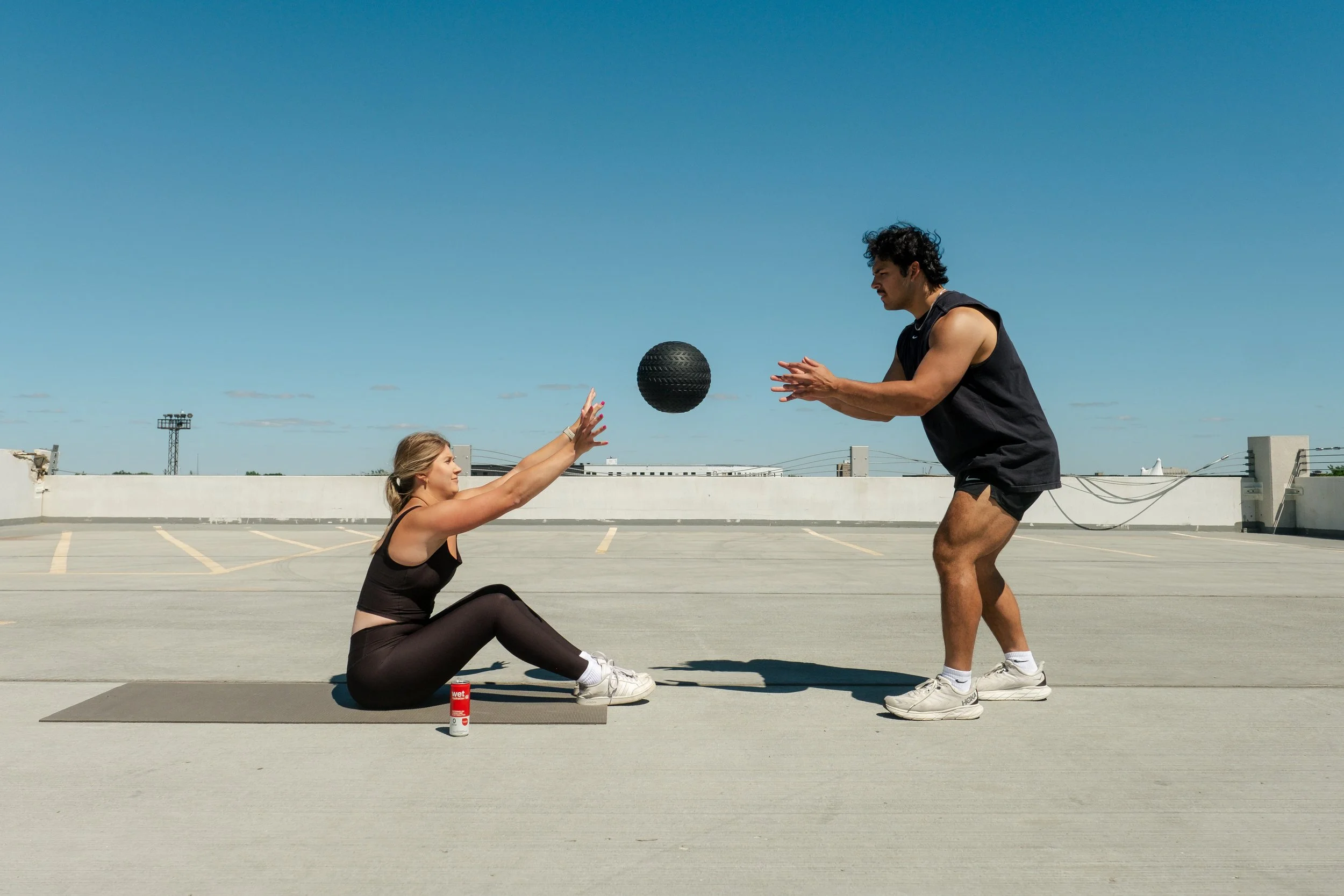 Man throwing medicine ball to woman