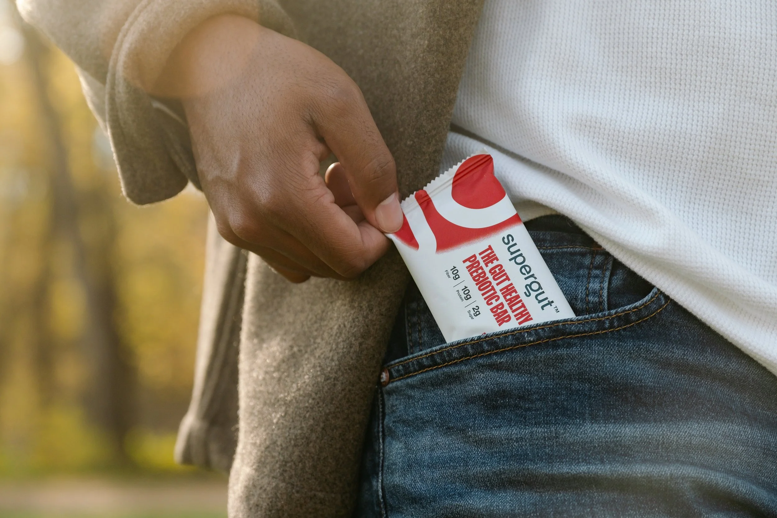 Black male hand pulling Supertgut bar out of his pocket.
