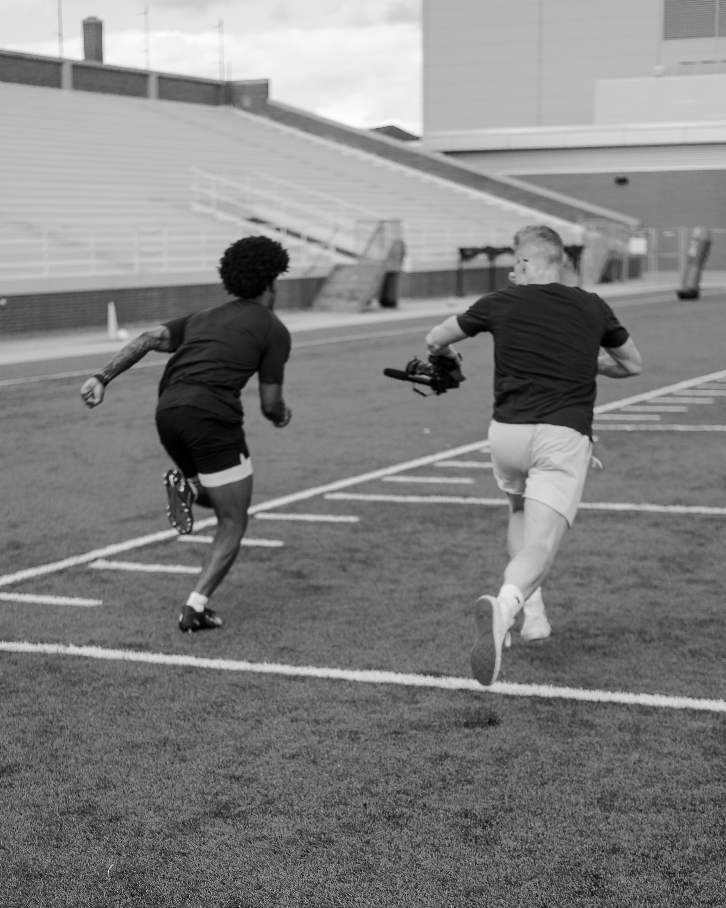 Andrew Stone Photography running alongside sprinting athlete while filming.