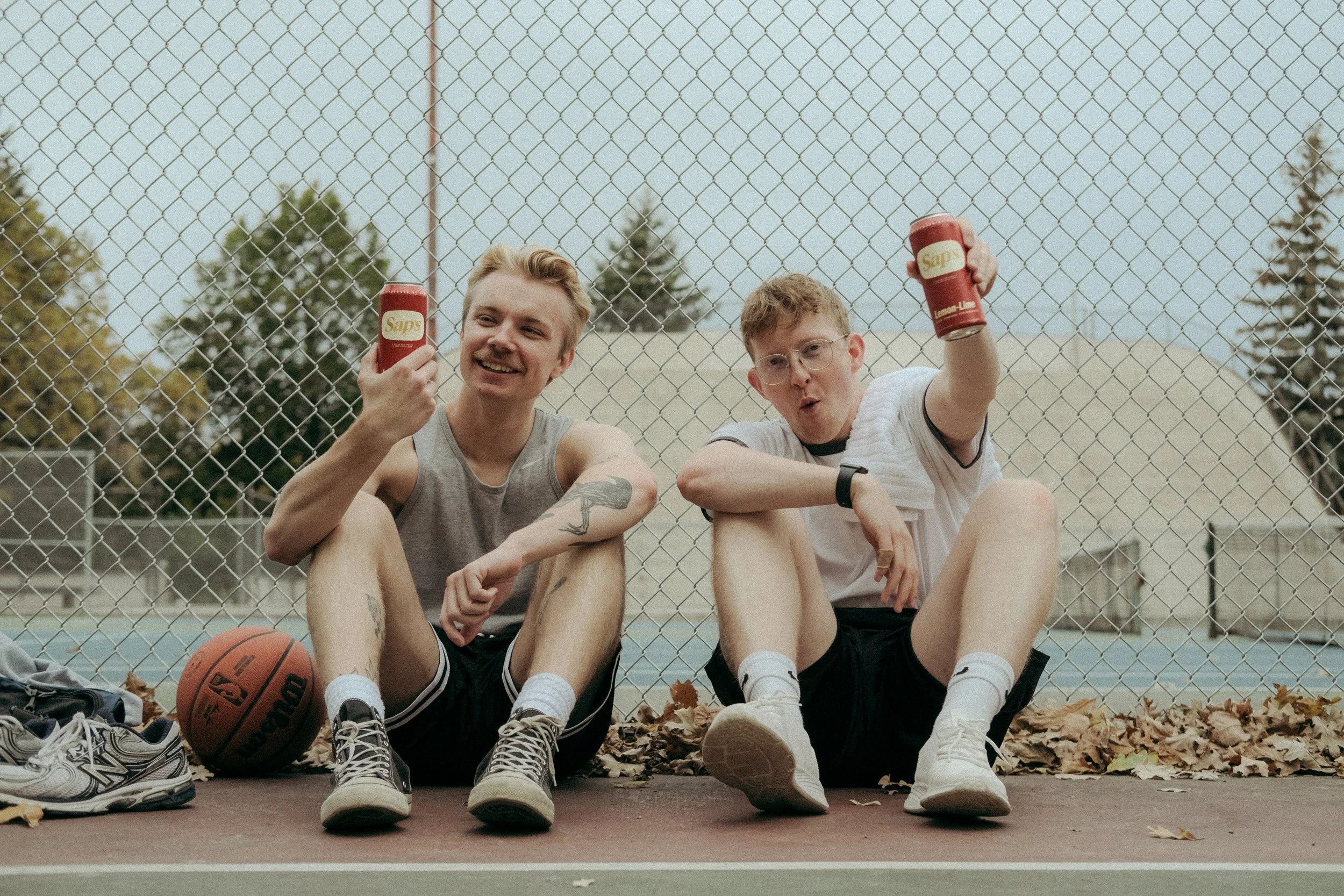 Two guys sitting down with Sap's drink.