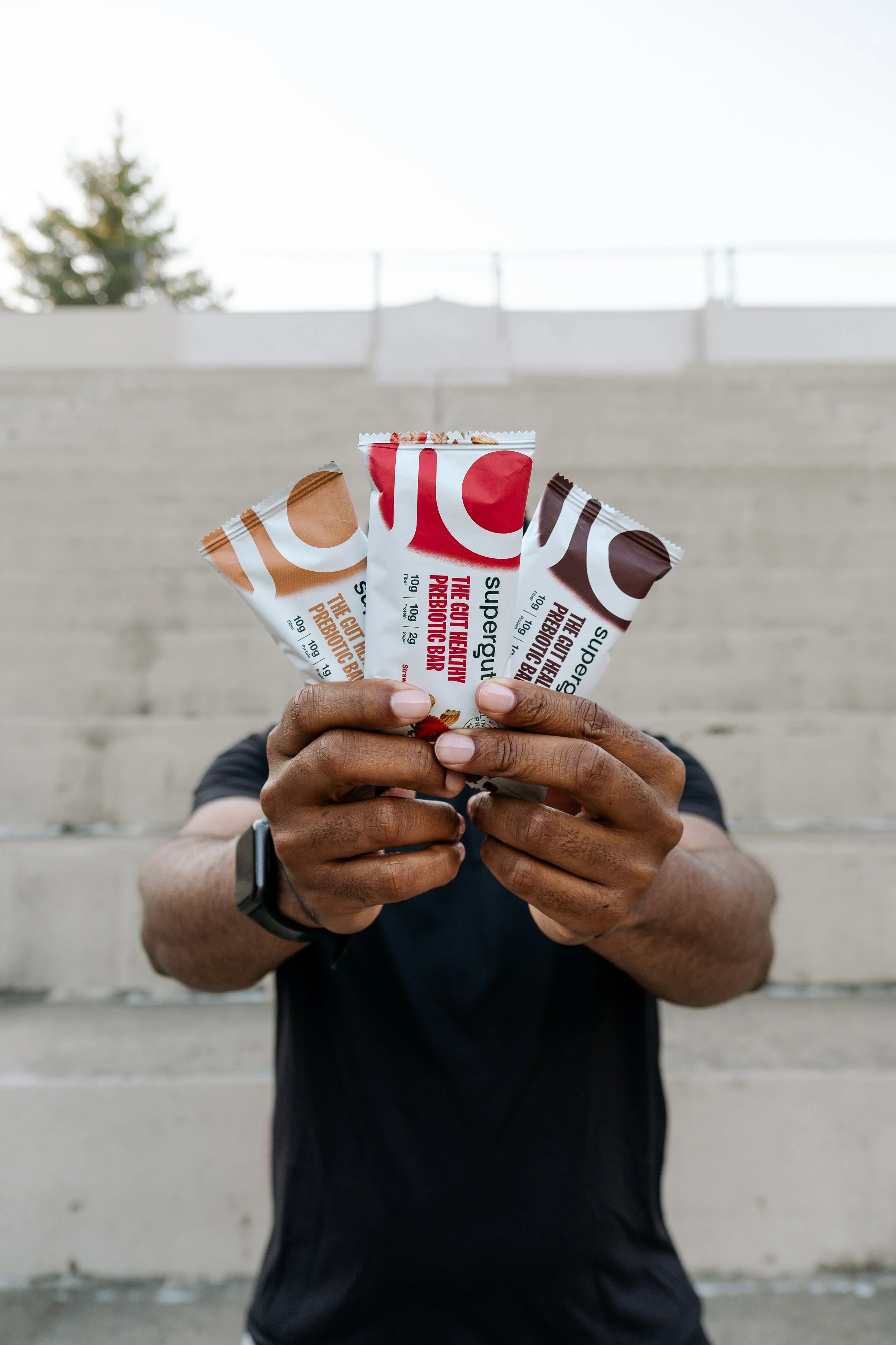 Black man holding protein bars.