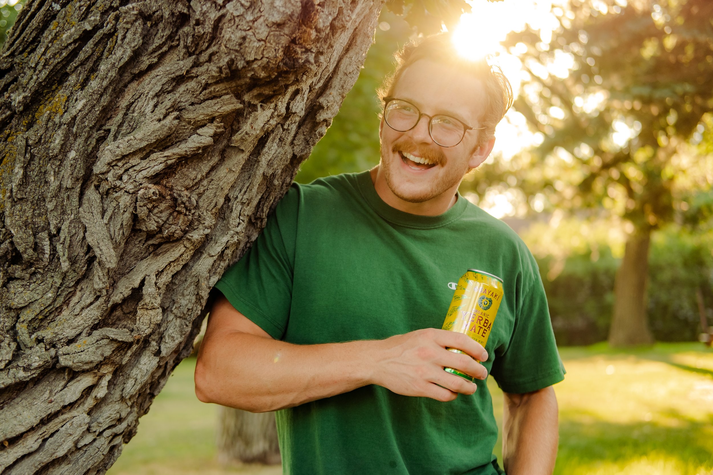 Man smiling and holding Yerba Mate outside.