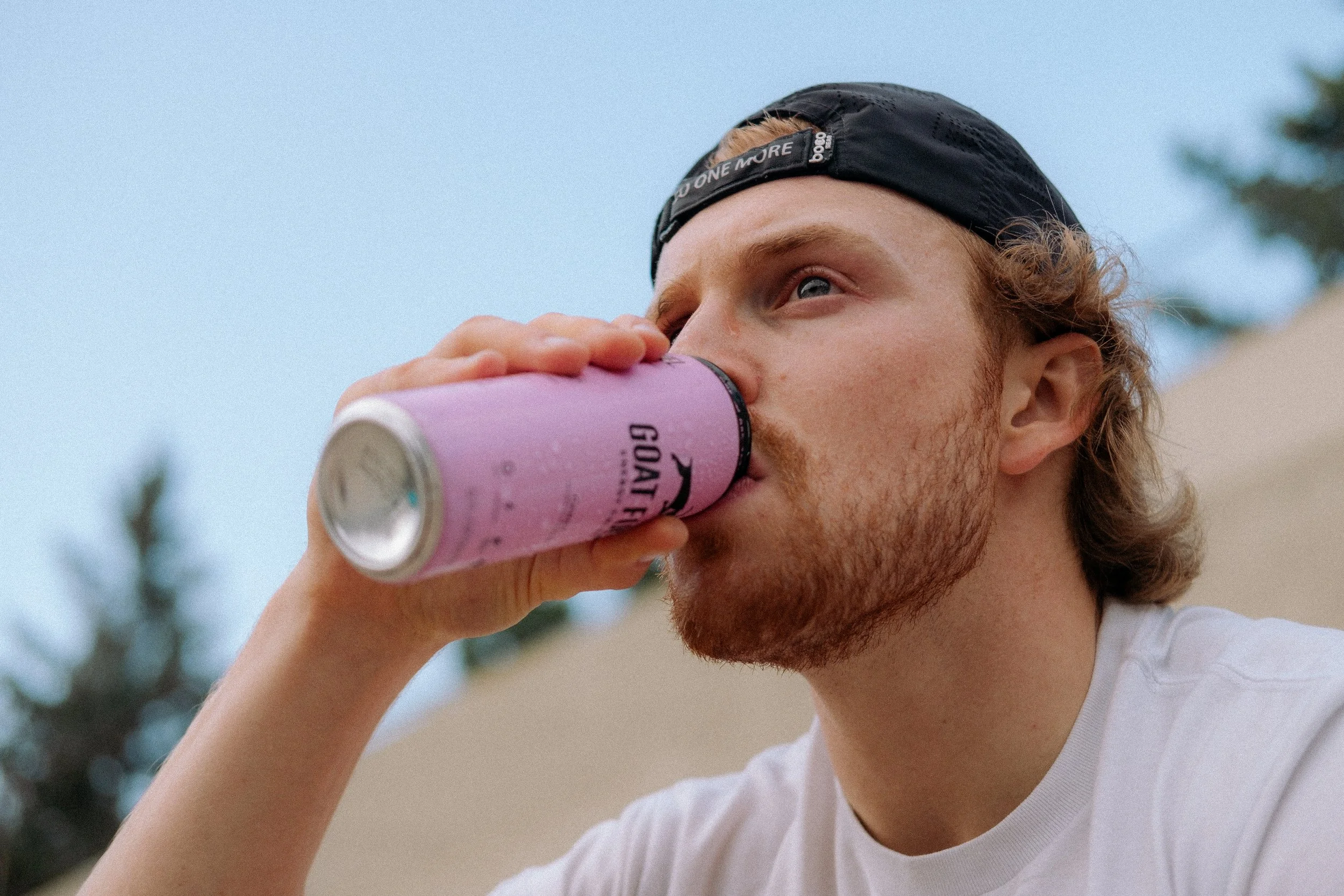Man drinking Candy flavored Goat Fuel outside.