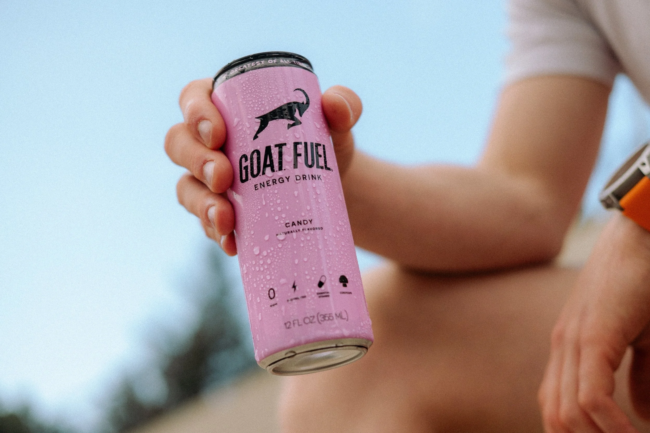 Man holding Candy flavored Goat Fuel outside.