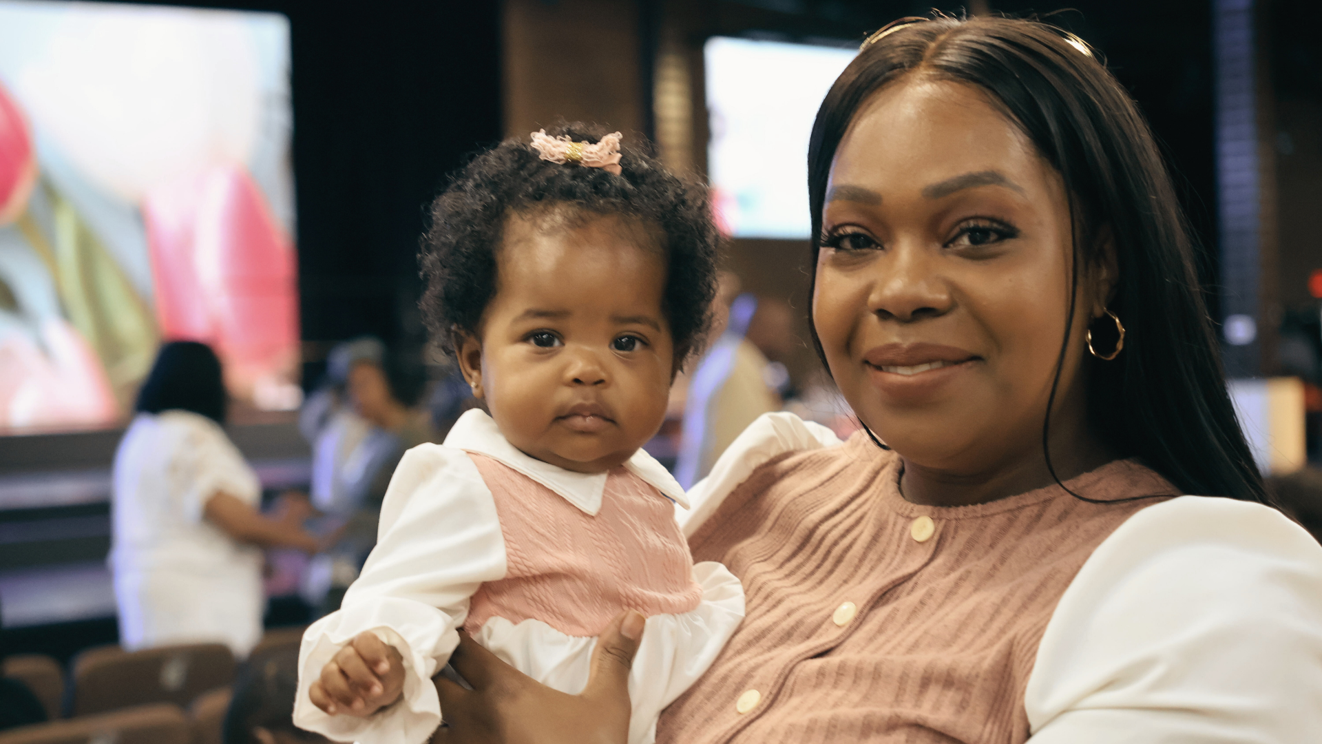 Family of four outdoors in a yard, smiling and posing for a photo.