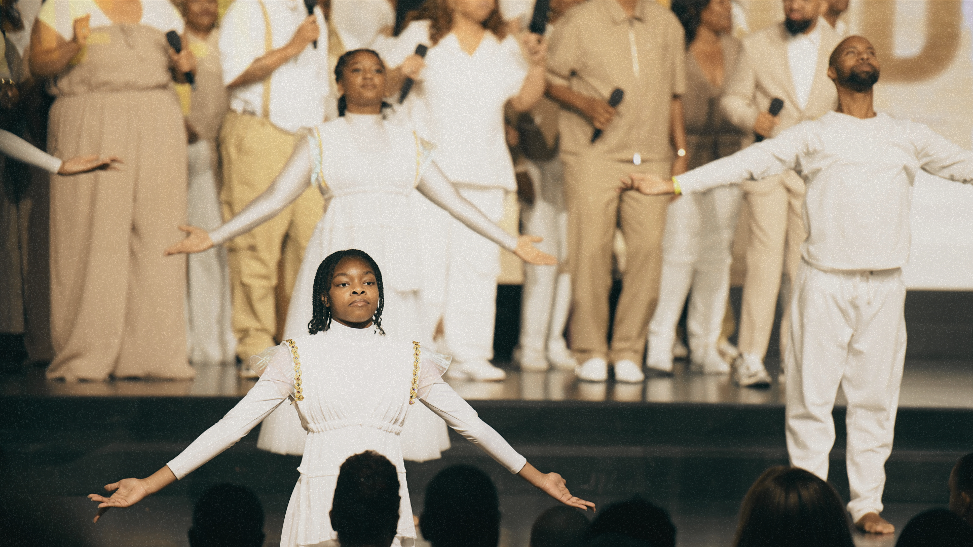 People dressed in historical and armor costumes standing outdoors around a man kneeling on a rock in religious or theatrical scene.