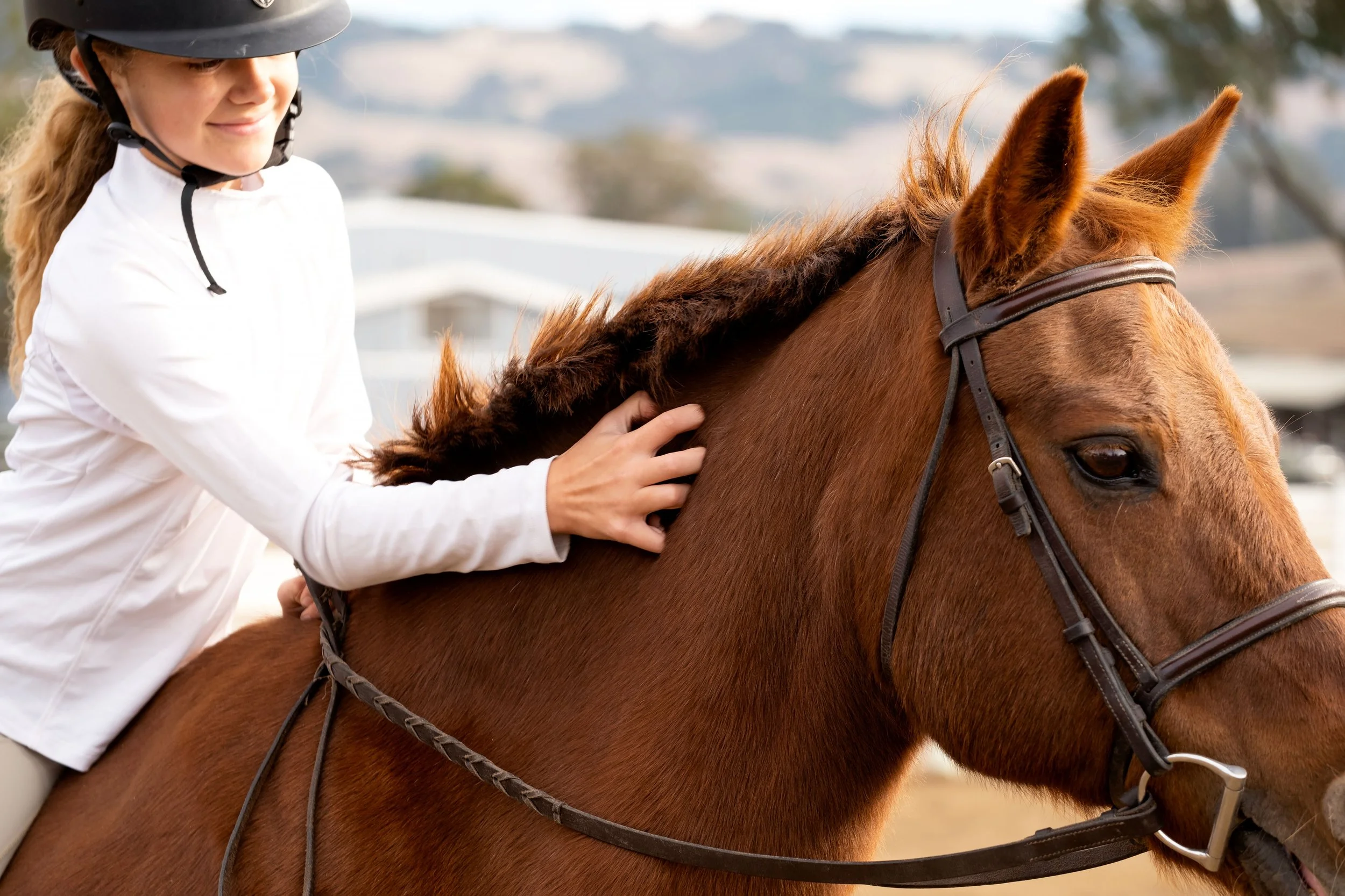1. A woman confidently rides a horse, embodying empowerment and connection through the Strides Legacy Program at Strides Riding Academy.
