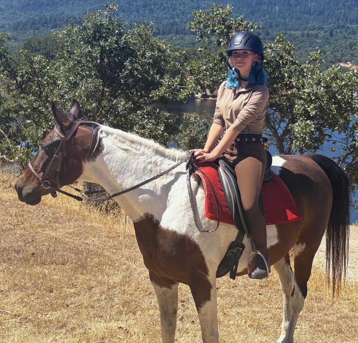 Rider enjoying a scenic trail ride at Strides Riding Academy with stunning Sonoma County hills in the background.