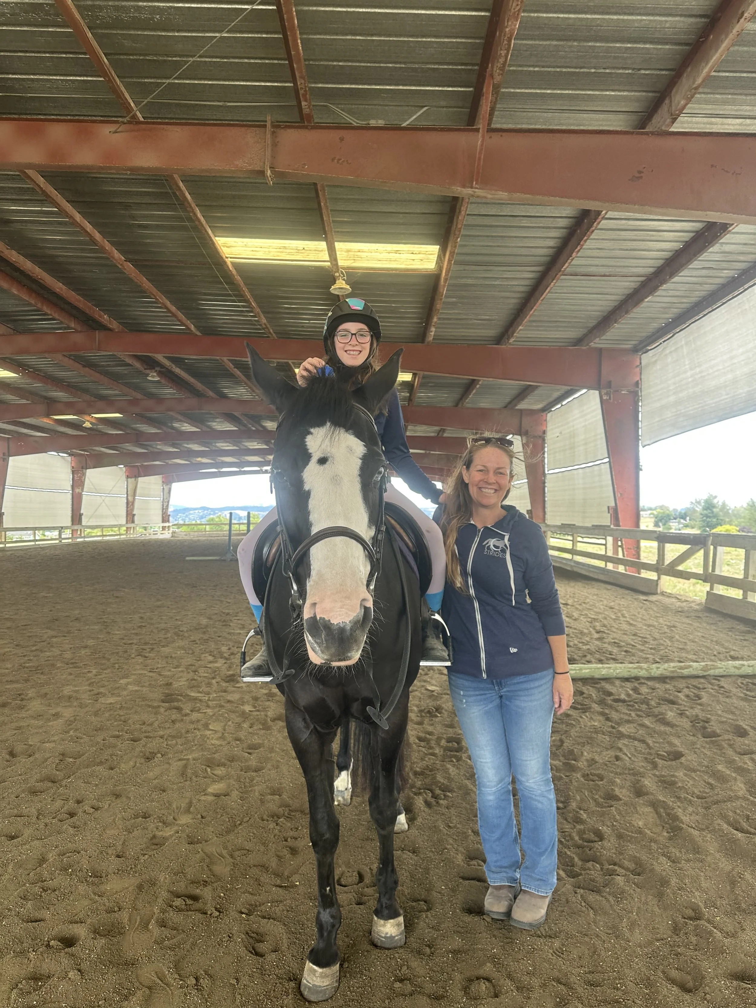 Young rider during an intro horseback riding lesson with instructor at Strides Riding Academy in Petaluma, Sonoma County