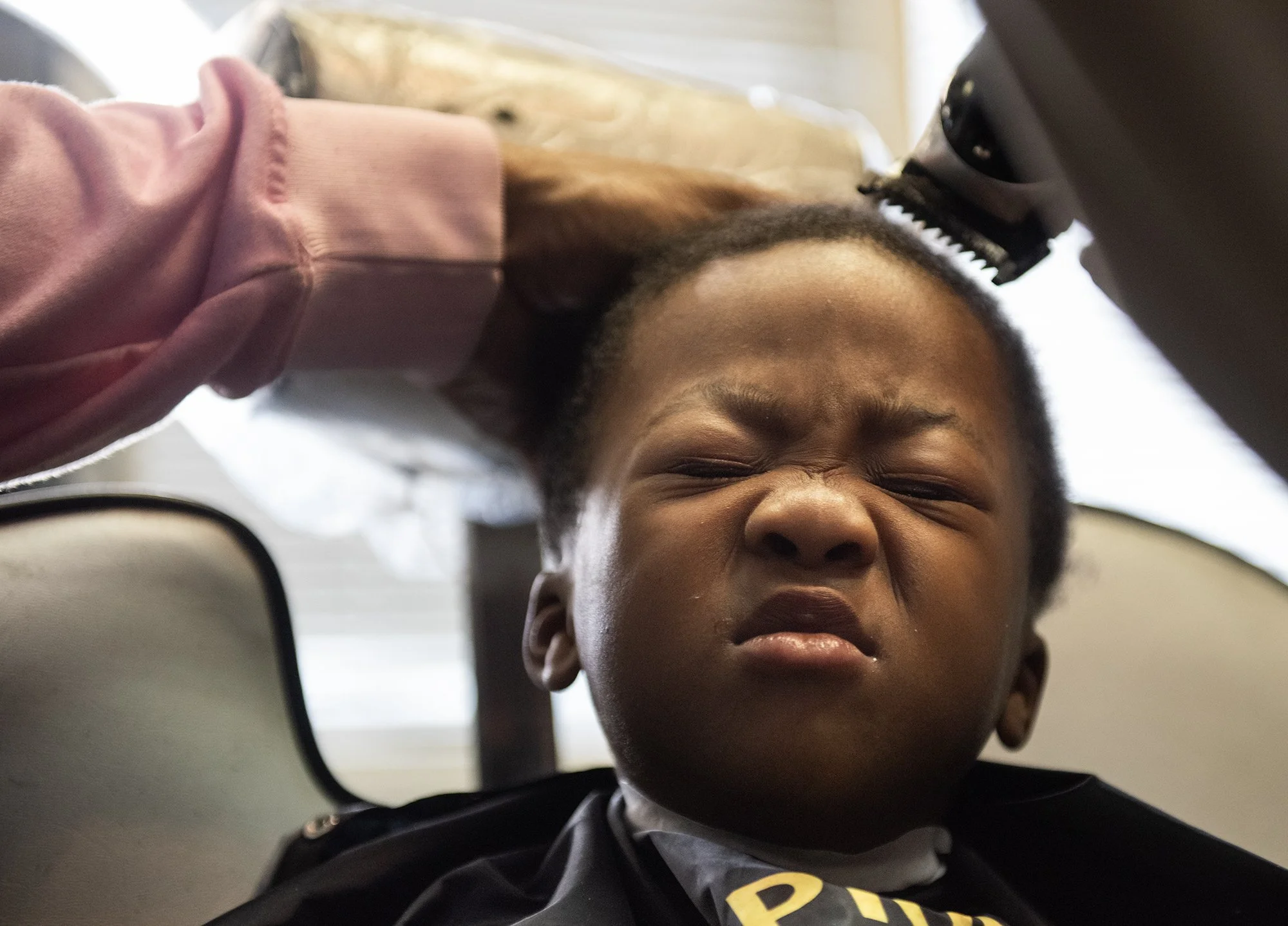  Caleb, 3, reacts as Ali Billingslea, known as Denzy to his customers, cuts his hair in Ridgeland, Miss., on Nov. 11, 2023. [Clarion Ledger] 