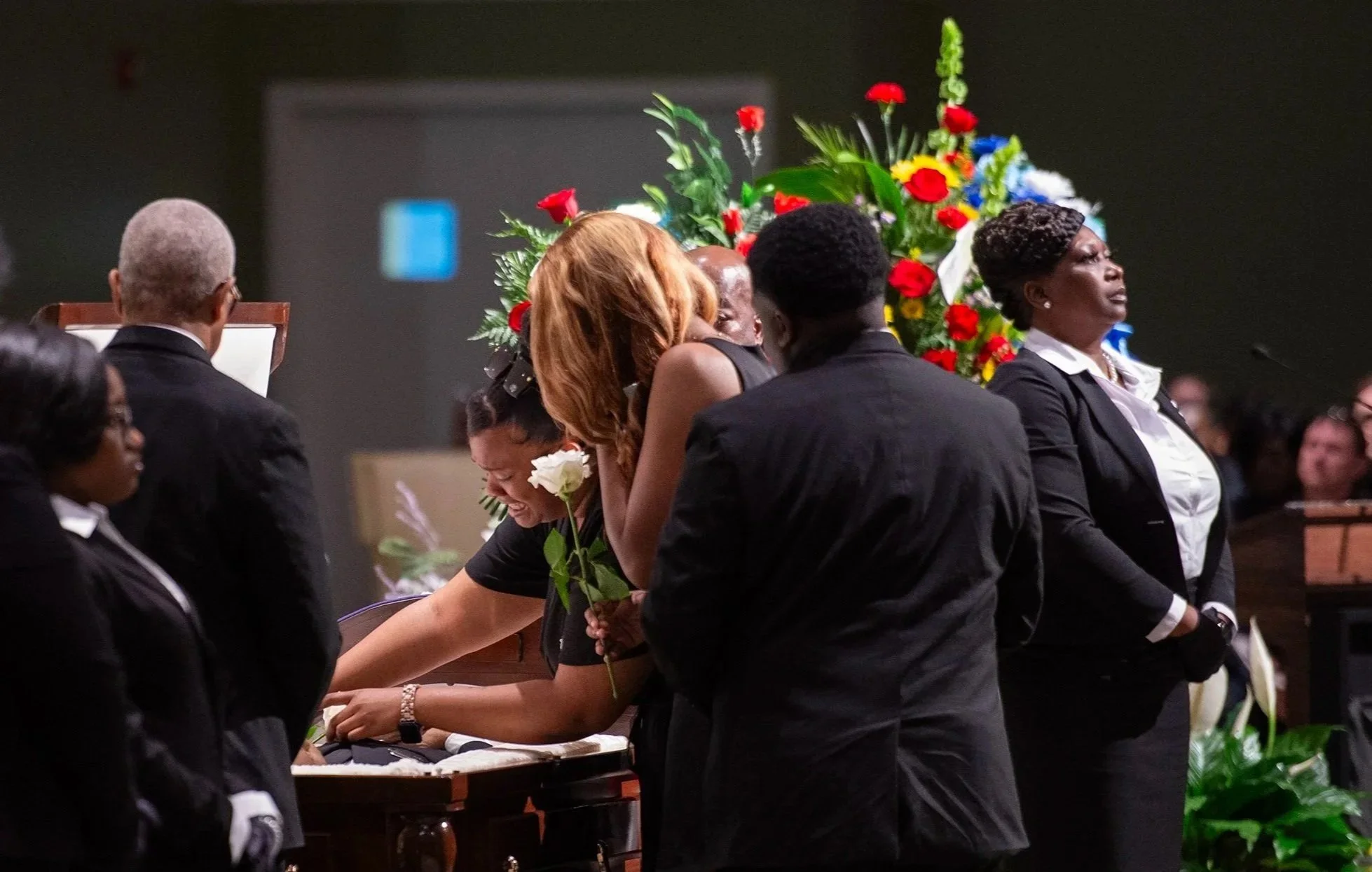  Daughters Gerrica and Mary Gerallisa Bates lay flowers on their father, veteran firefighter Gerald Bates, at New Horizon Church International in Jackson, Miss, on April 20, 2024. [Clarion Ledger] 