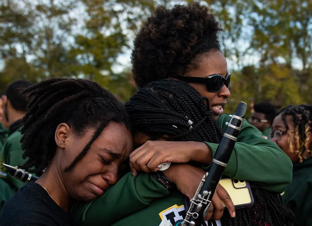  Dana Bolden (left), Jamaya Bailey (middle) and Ariyana Osborne (right) hug as the celebration of life ceremony ends for Chris Little, Jim Hill High School's band director, at Isable Elementary School in Jackson, Miss., on Dec. 19, 2023. "He's the be