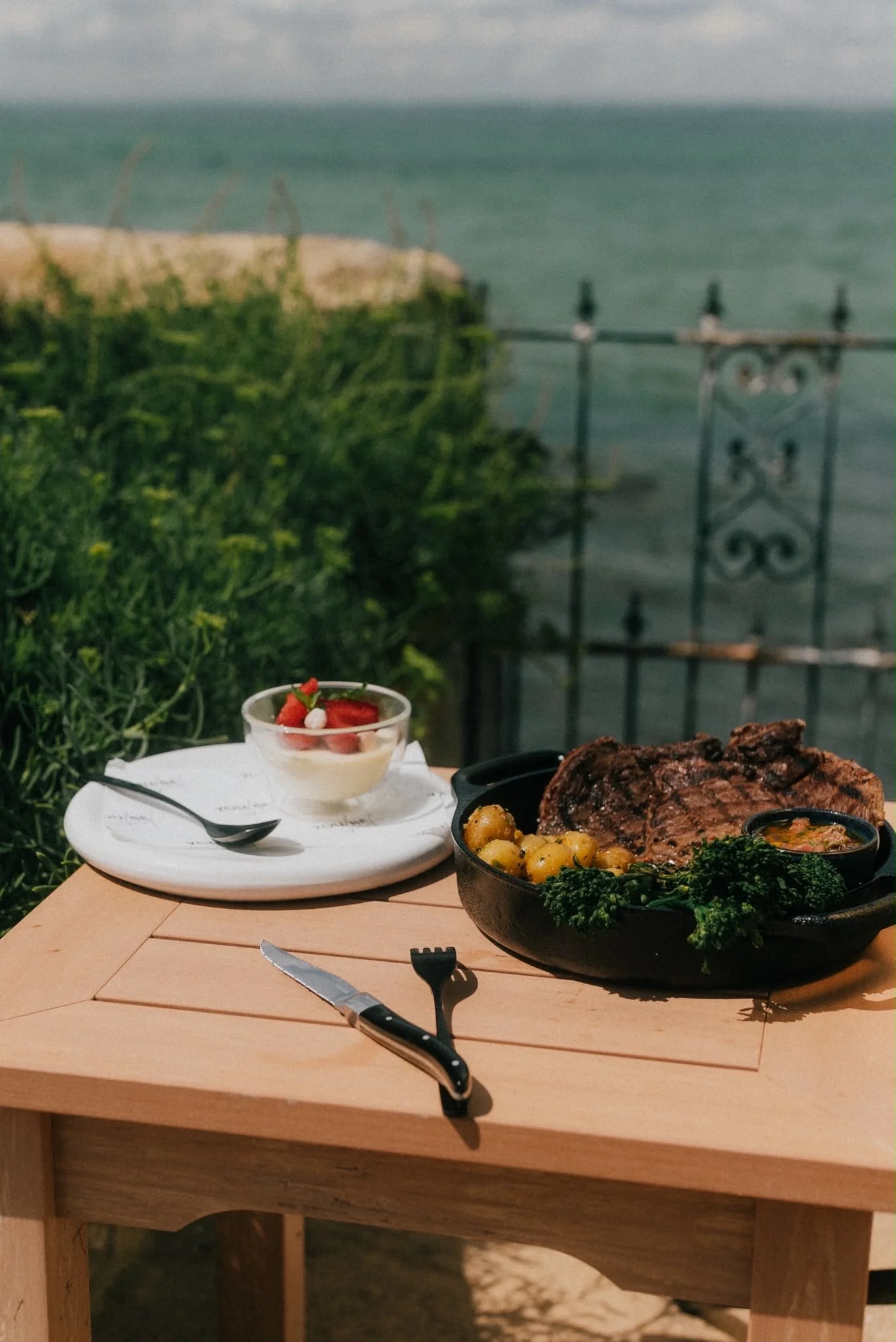 A table set with YouBeChef ribeye steaks, focaccia, vegetables and desserts for two