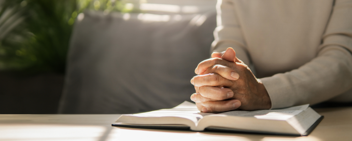 person with wrinkled hands on open book in bremerton, washington