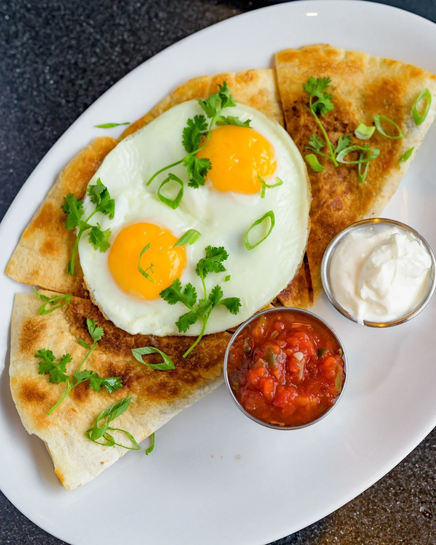 Game day calls for a good brunch first. 🏈🍳 Our Huevos Rancheros brings a little heat to the table with two eggs, a crispy quesadilla, and fire-roasted salsa, making it the perfect fuel before tackling the action at Gillette Stadium. Stop in for bru