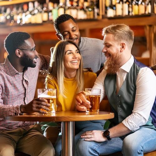 Firefly men and women of different ethnicities mingling in a pub with a drink 92959.jpg