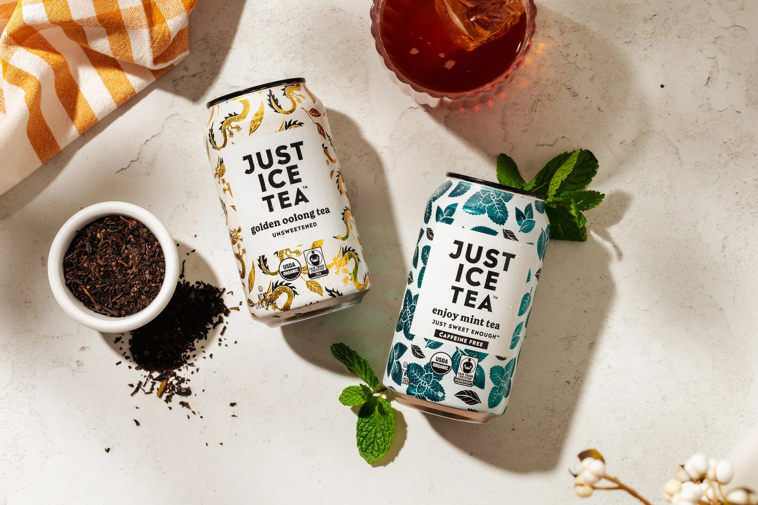 Just Ice Tea lying next to its ingredients in a flatlay product photo