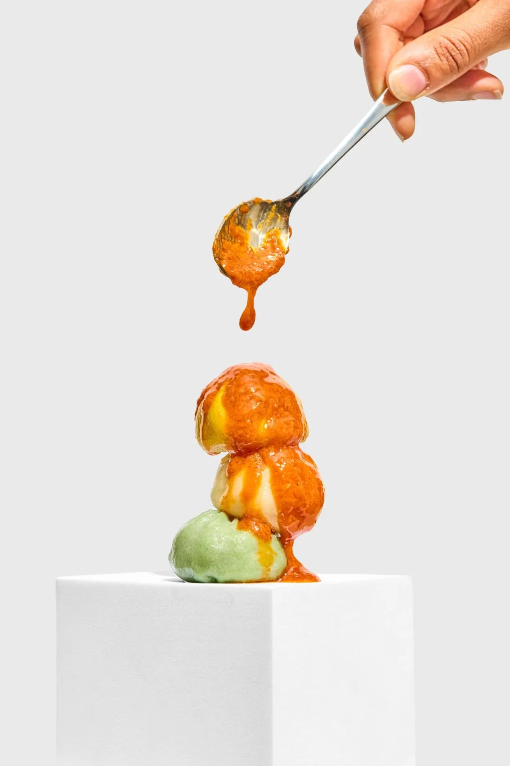 A shot from a food photography session with sauce being poured on stacked dumplings