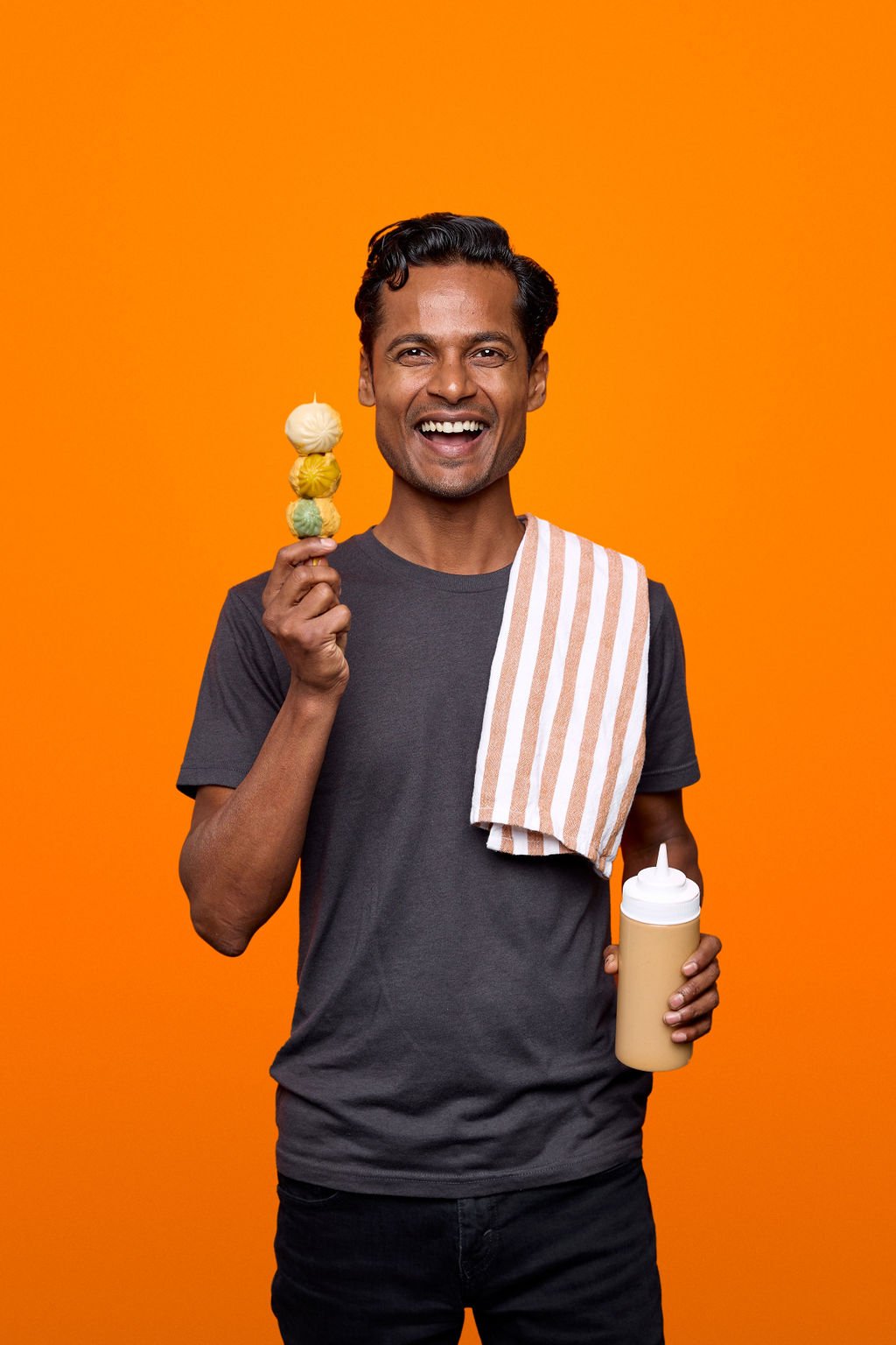 A man holding dumplings on a stick