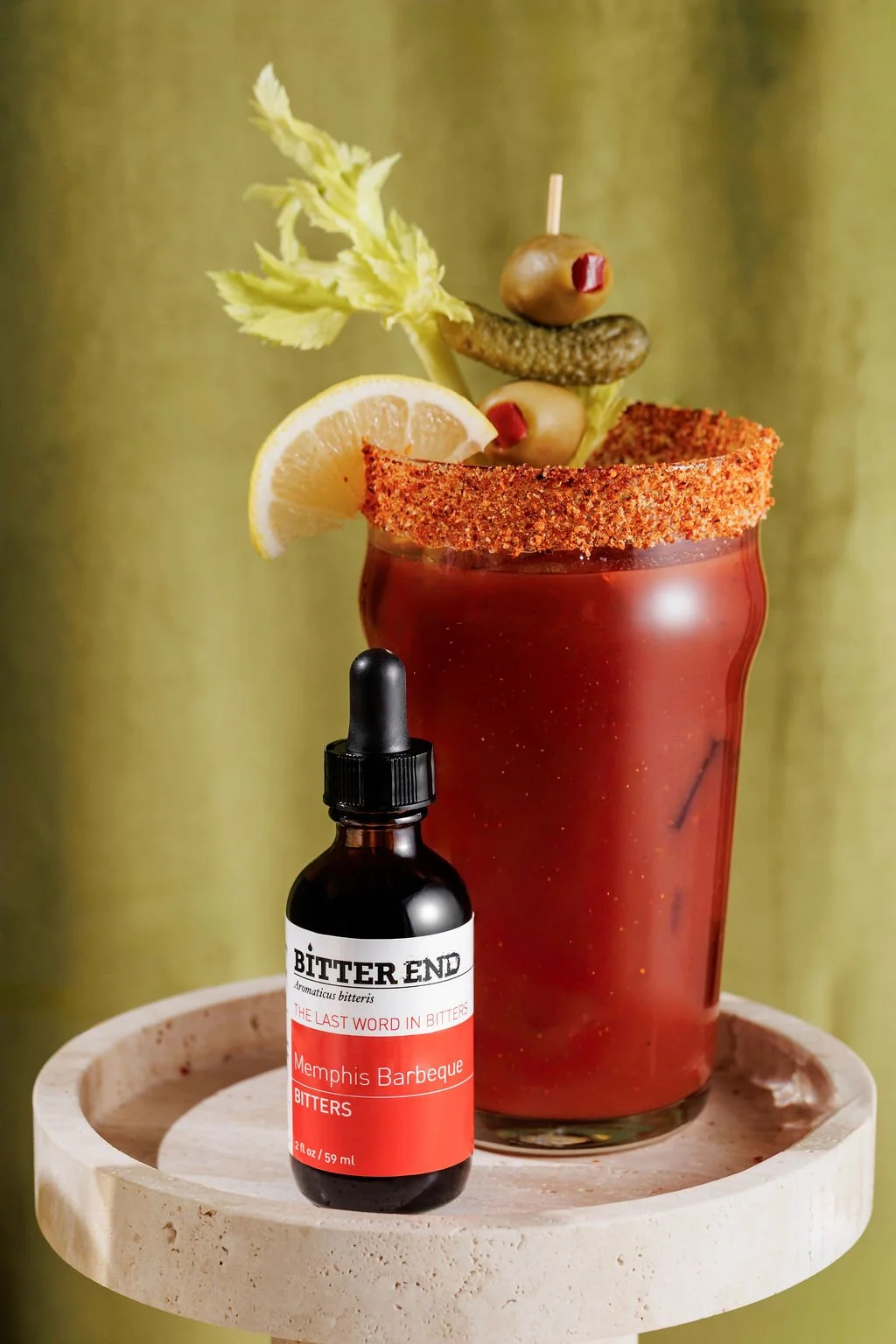 A bottle of bitters in front of a cocktail