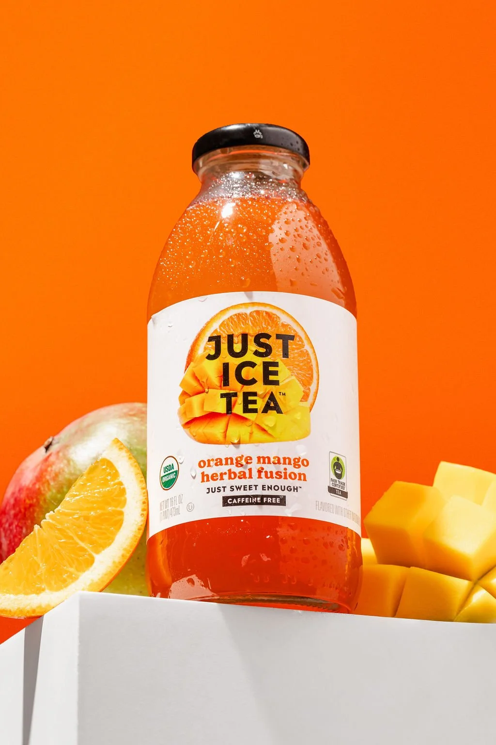 An orange Just Ice Tea in a studio photo backdrop for a brand photoshoot