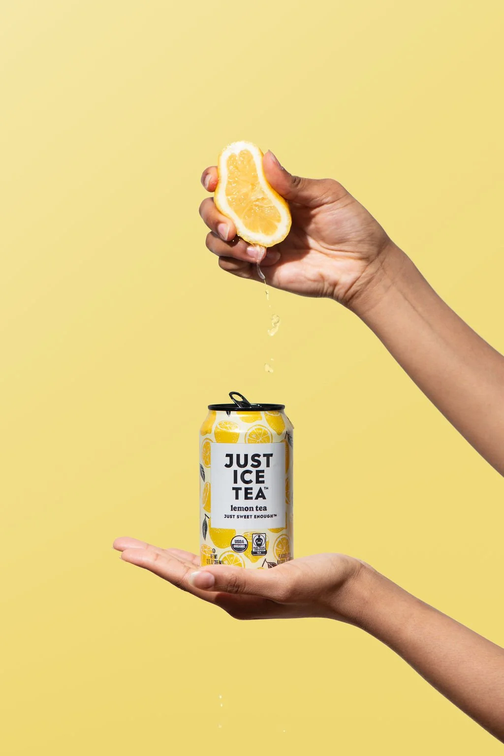 Someone squeezing lemon into an iced tea can in a brand photoshoot