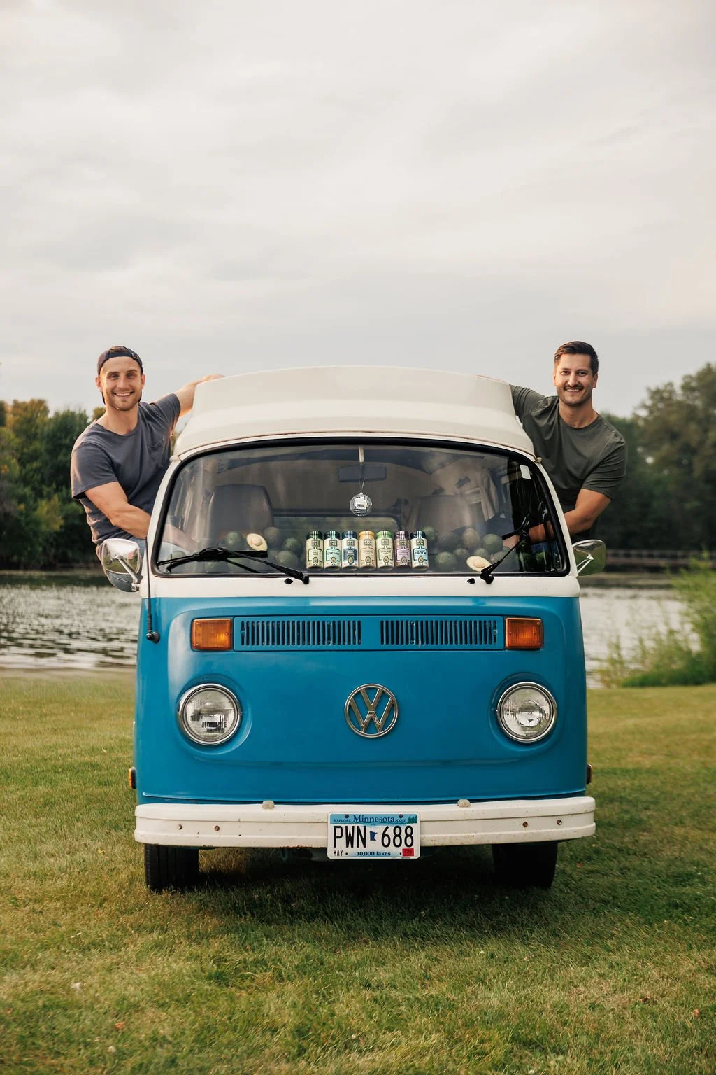 Two men in a vintage van with brand stickers for their brand photography