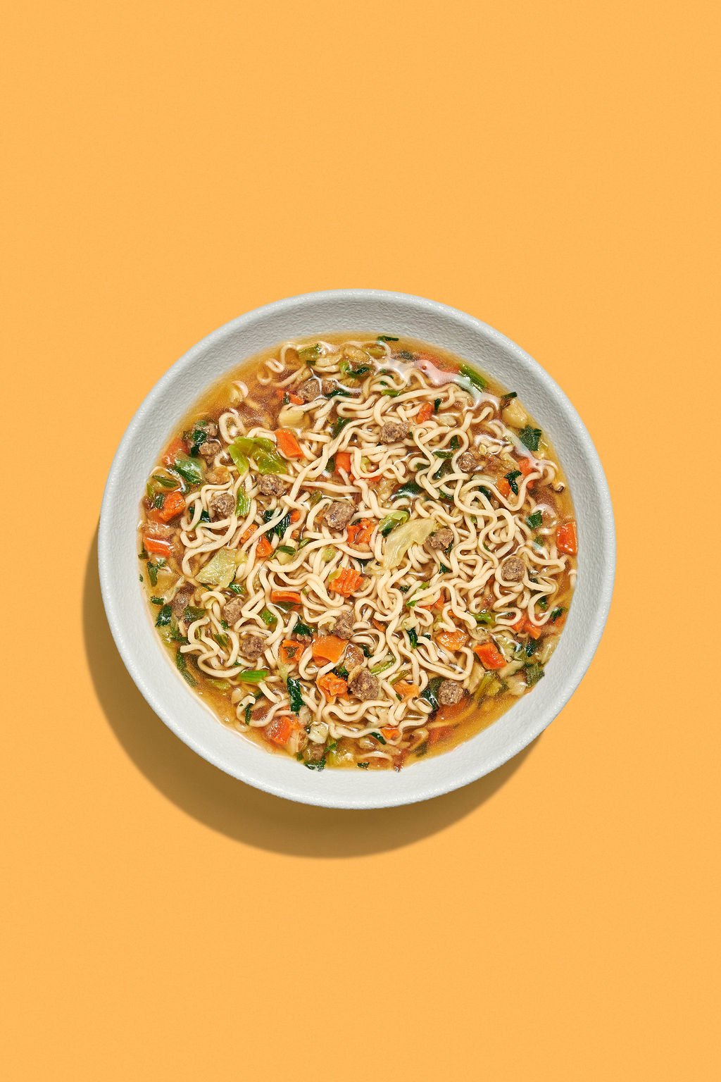 Food photography trends showing a bowl of ramen on a bold backdrop