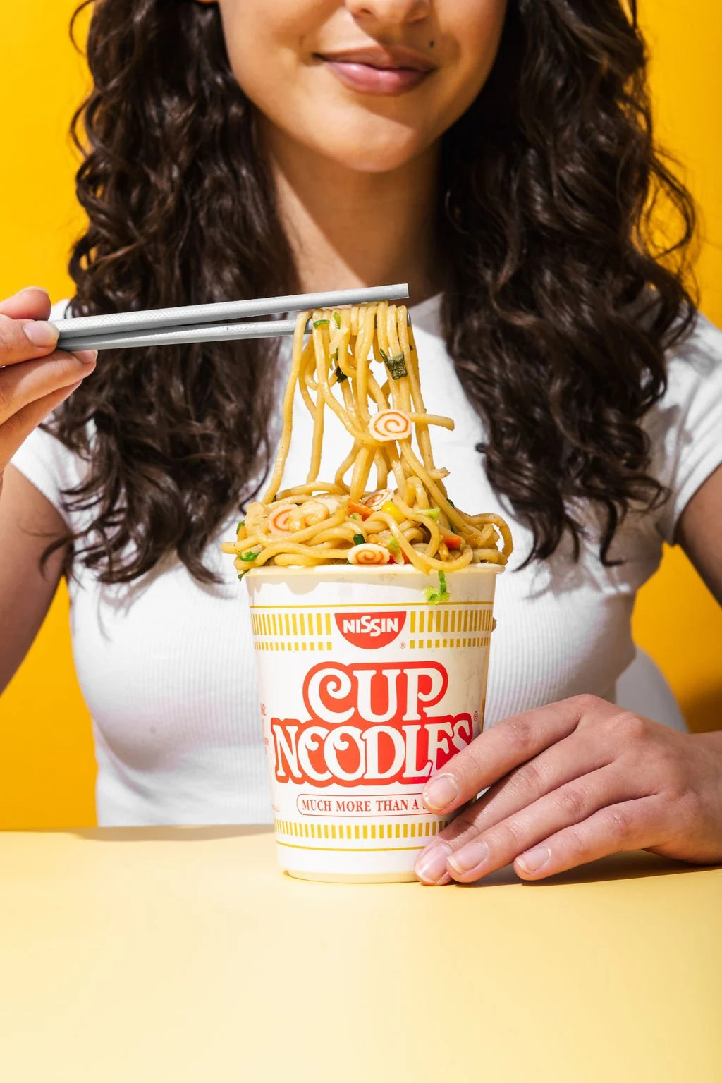 A woman eating ramen for product photography