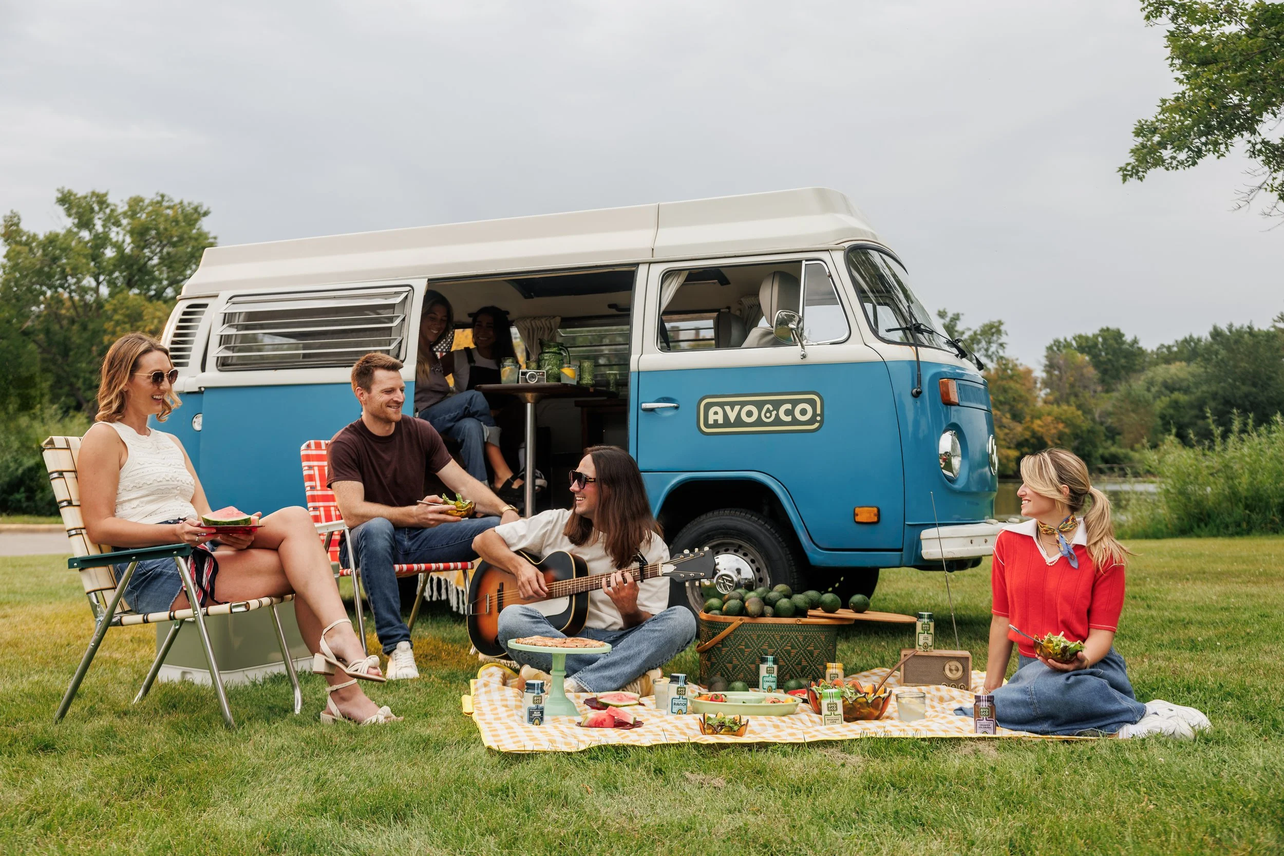 A picnic staged for brand photography with a blanket and a volkswagen van
