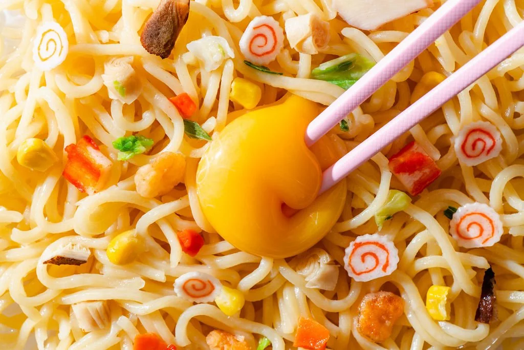 An egg yolk in a bowl of ramen in food product photography