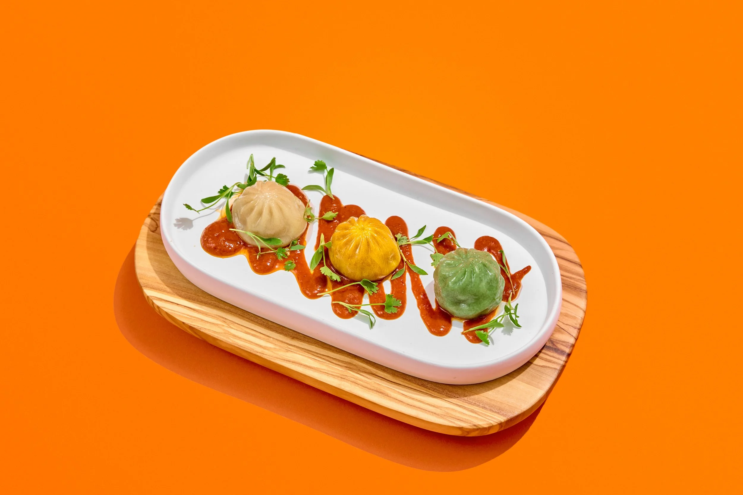 A photo of dumplings taken with an orange studio background from a food photography shoot