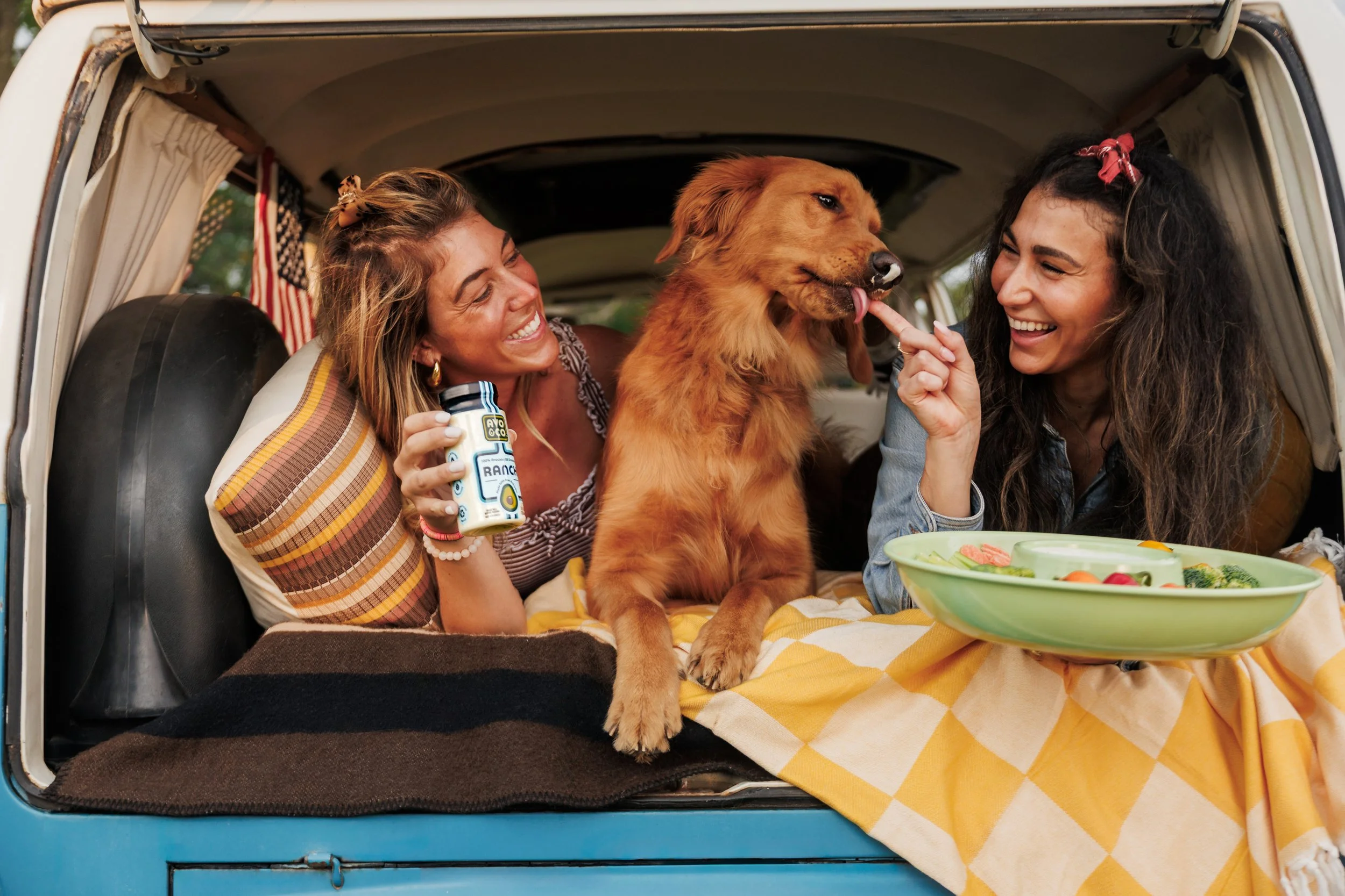 Two women and a dog in a van for brand photography