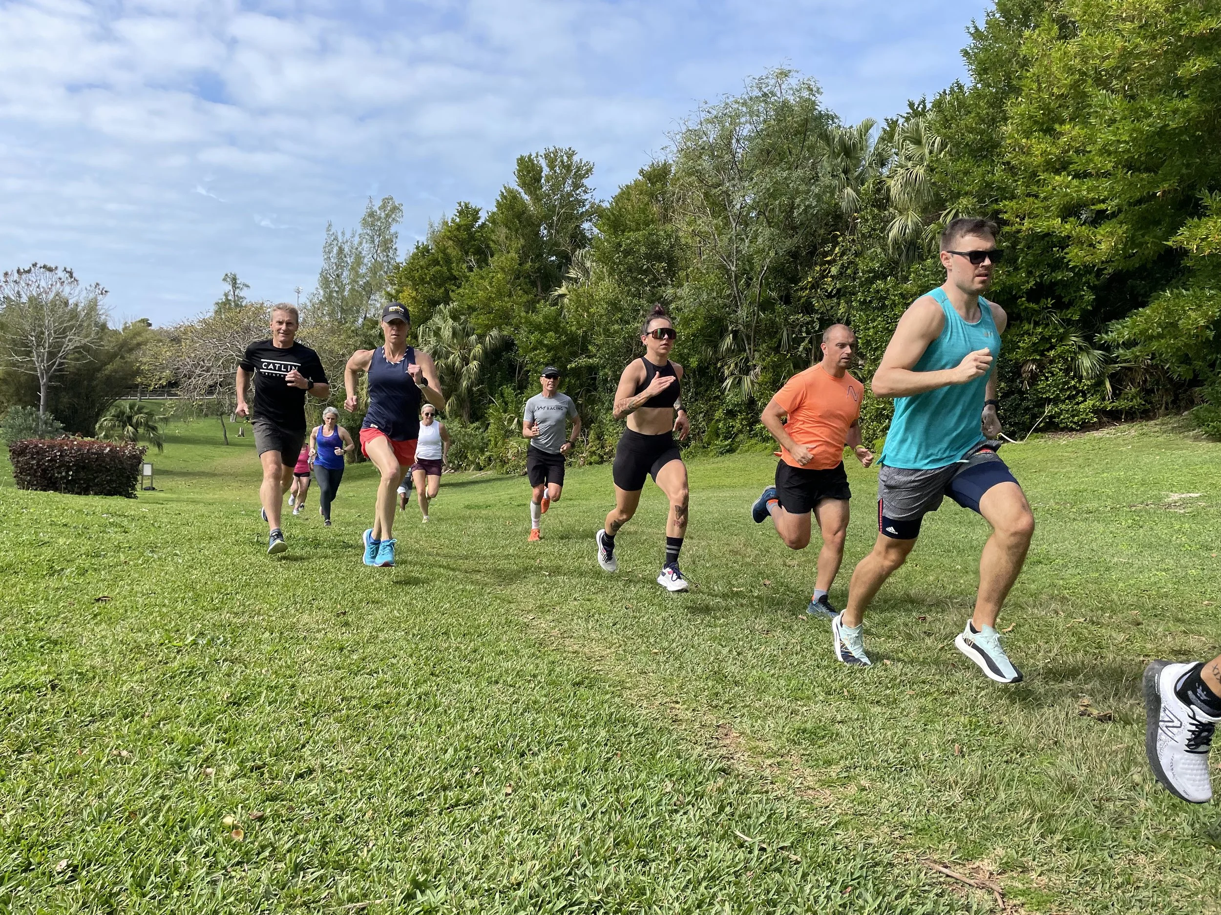 A group of runners enjoying a hill rep workout on grass