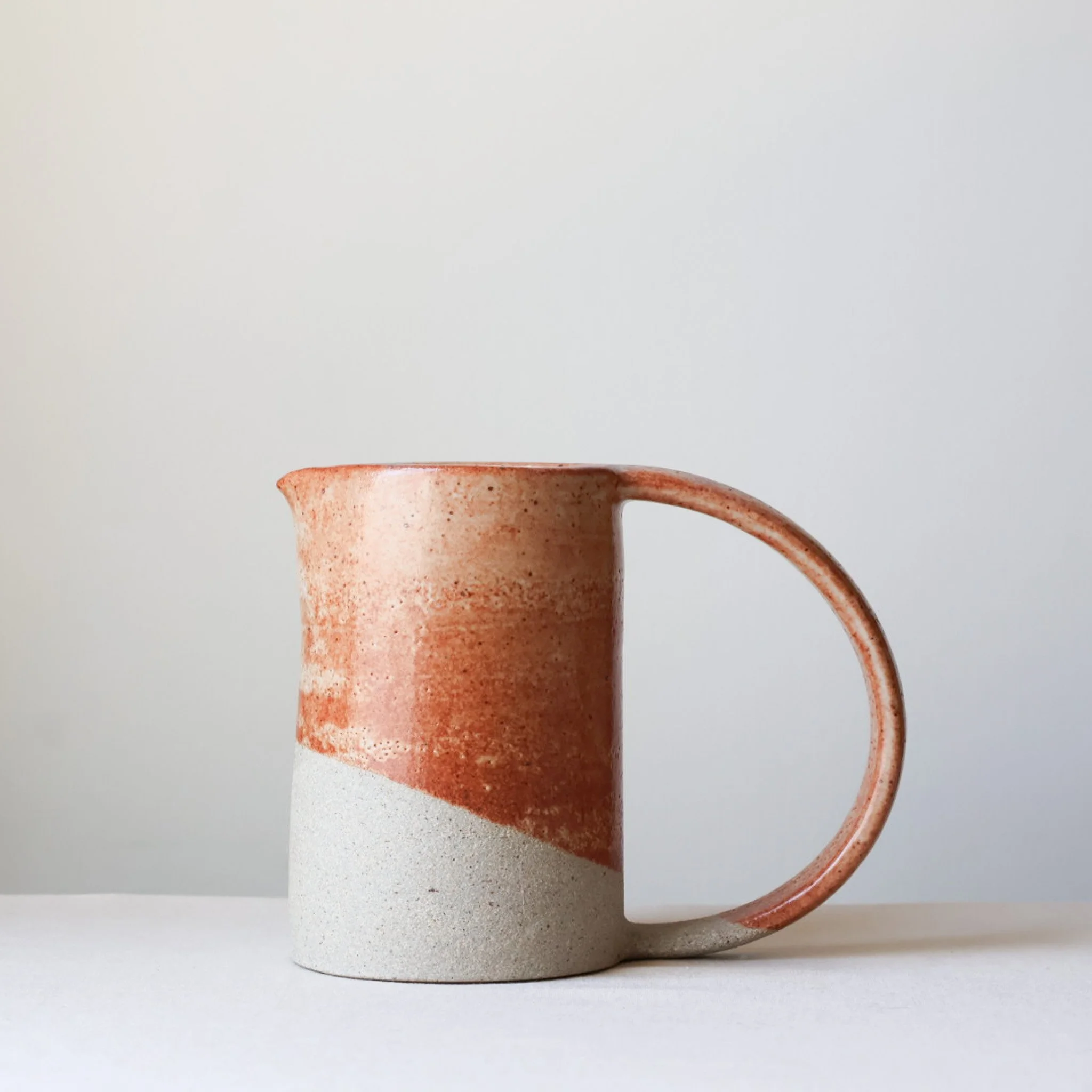 cream-rusty-coral-arc-handle-pitcher-1.jpg