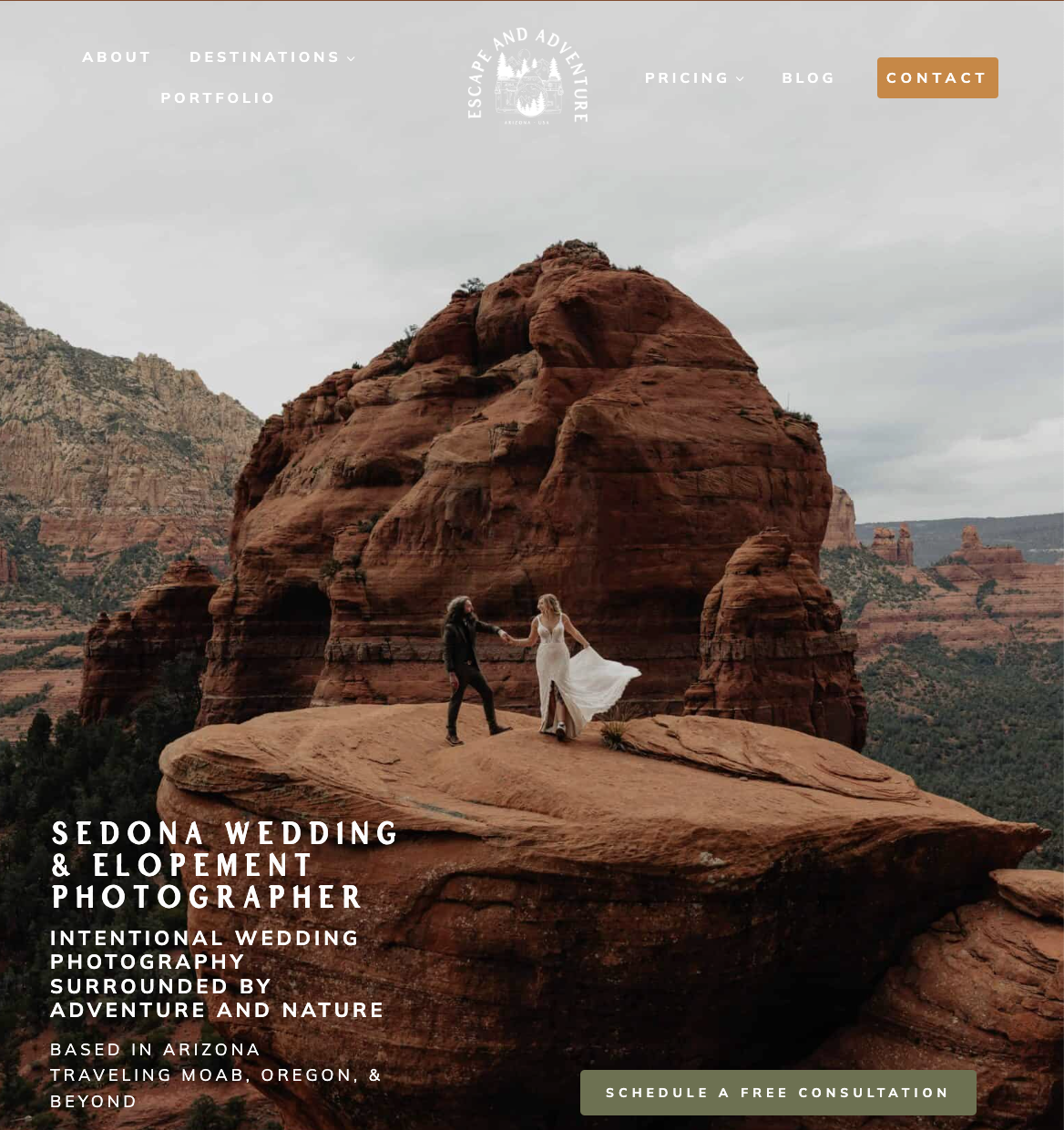 A couple in wedding attire standing on a large rock formation in Sedona, Arizona with a mountainous desert landscape in the background.
