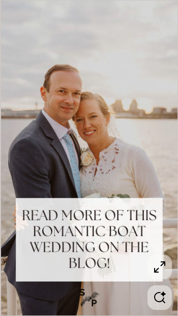 A happy bride and groom standing outdoors by a body of water during sunset, smiling at the camera with city skyline in the background, with text overlay promoting a blog about boat wedding stories.