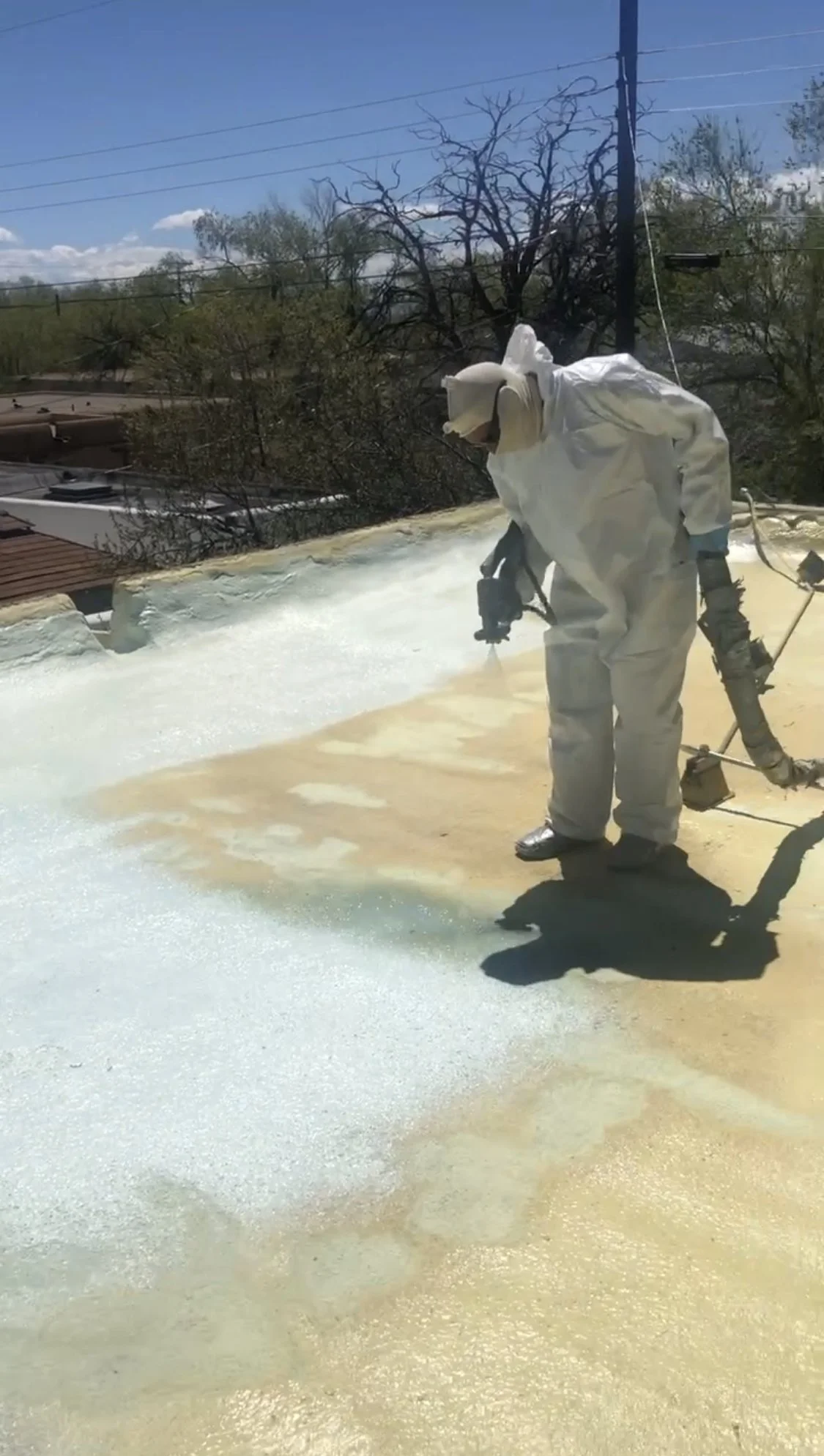 Crew member applying roof coating