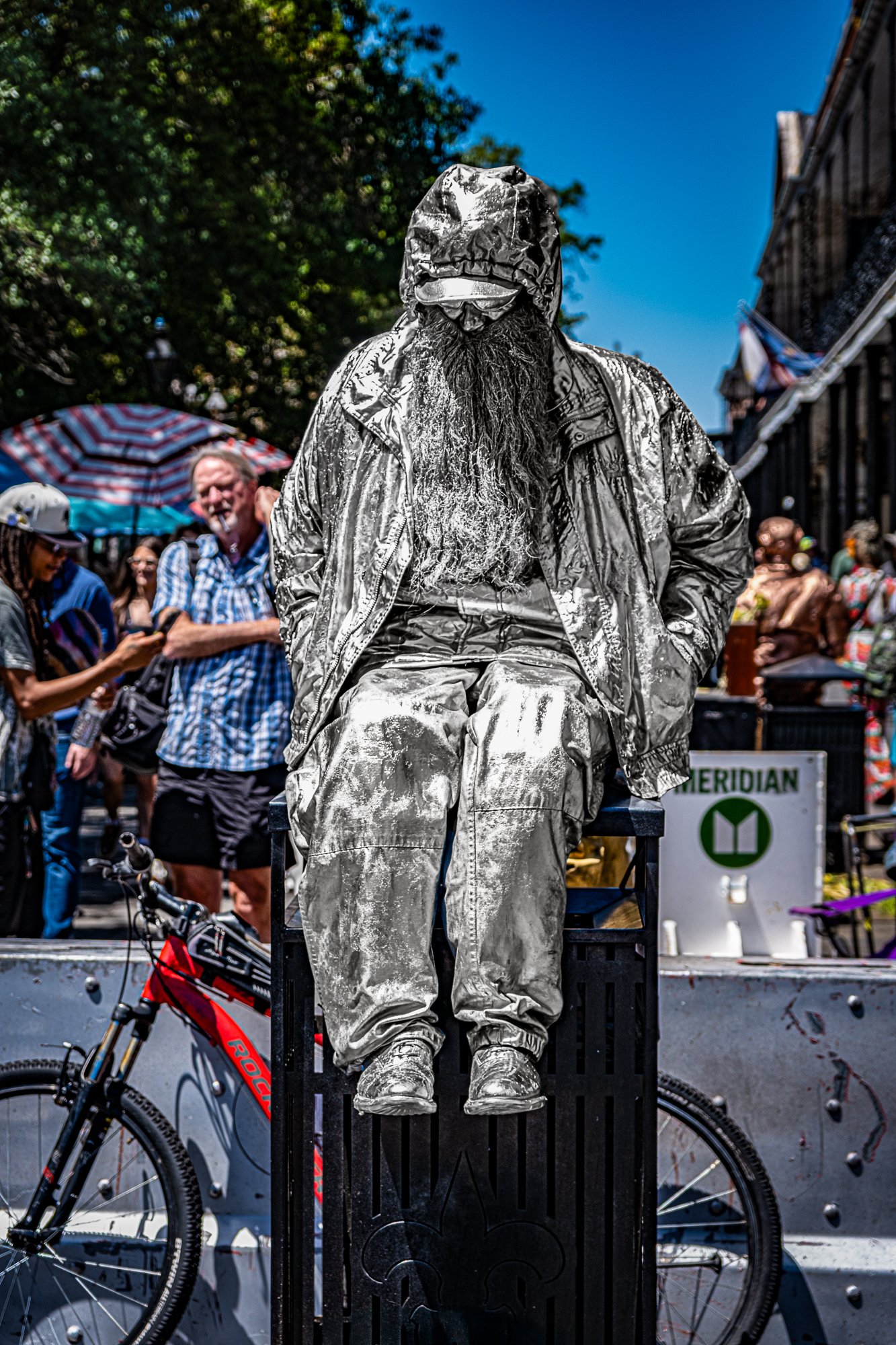 Just beyond the carriages and cathedral steps, a silver figure stands frozen—face painted, arms steady, unmoving in the heat. A living statue. Or maybe not. Is it a man beneath the paint? That’s part of the magic. You’ll have to look closely, and eve