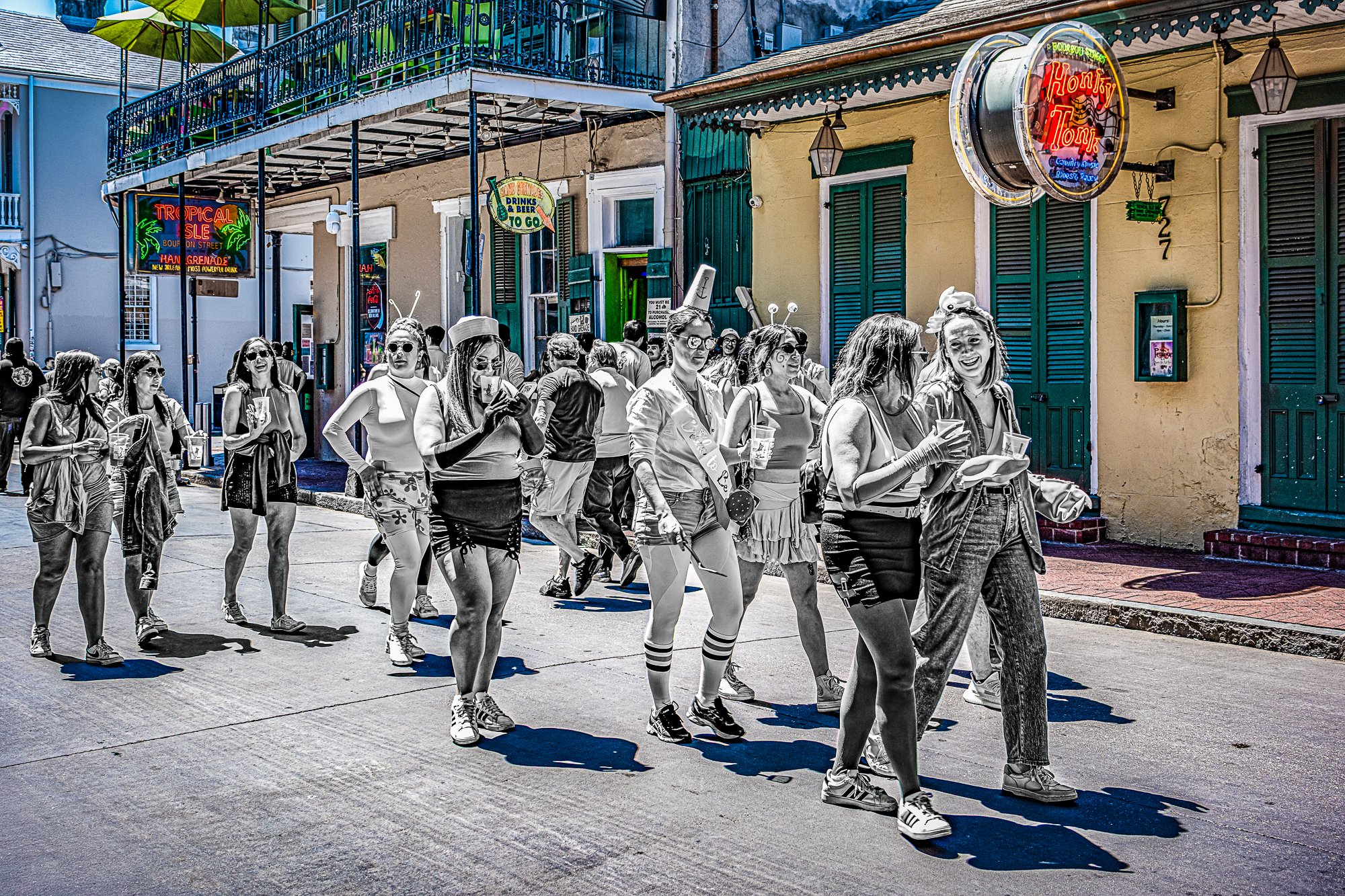 Back on Bourbon, the energy is full tilt again. A bridal party parades through in silly headbands and costumes, laughing louder than the music. They aren’t trying to blend in—no one does here. For a moment, they own the block, and the Quarter joins i