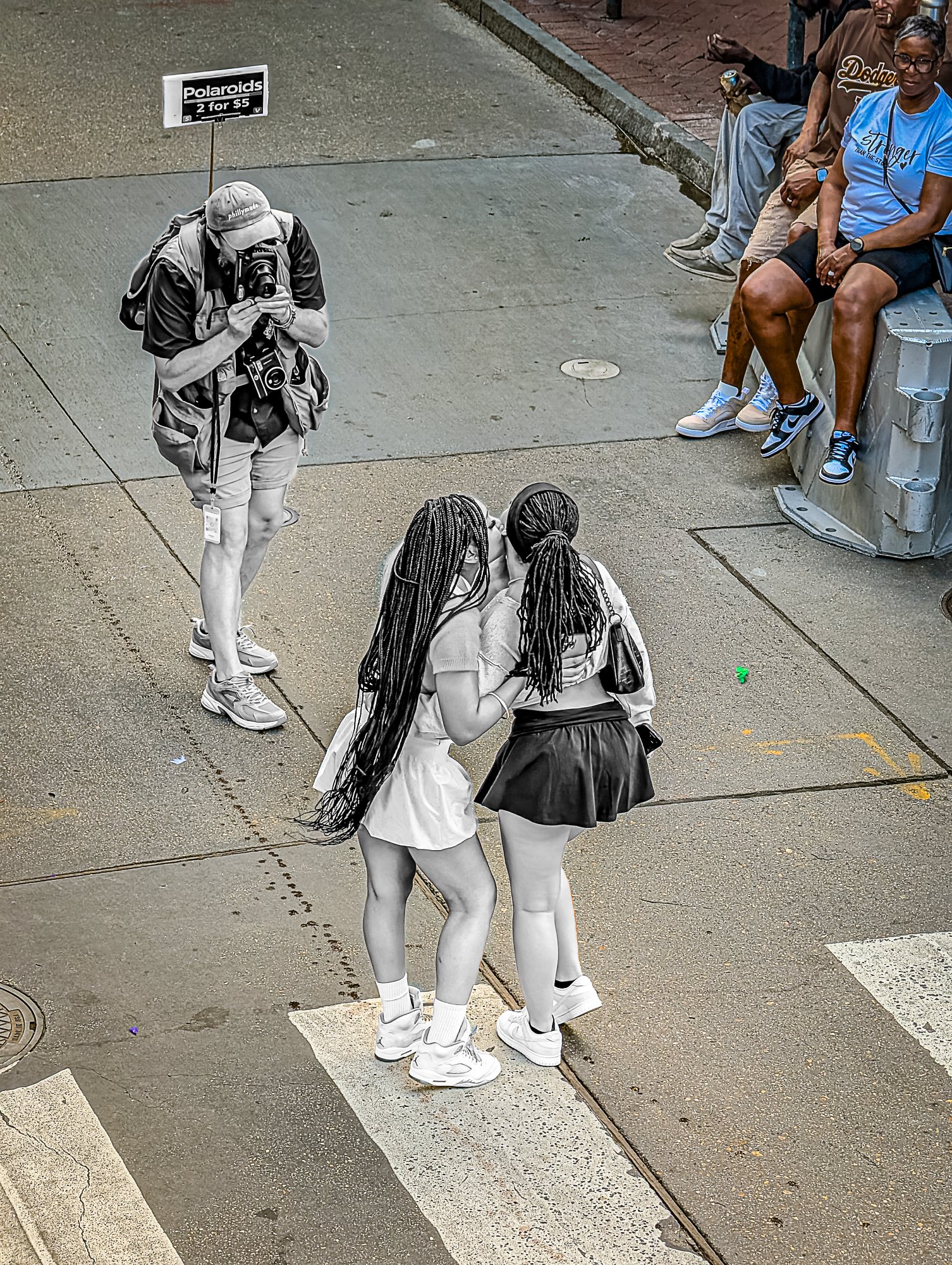 Just off the curb, two girls stop to snap a photo—laughing, posing, lit by the buzz of Bourbon behind them. It’s quick and casual, but intentional. A memento in the making. Maybe it’ll live on their lock screen, or maybe it’ll get buried in a photo d