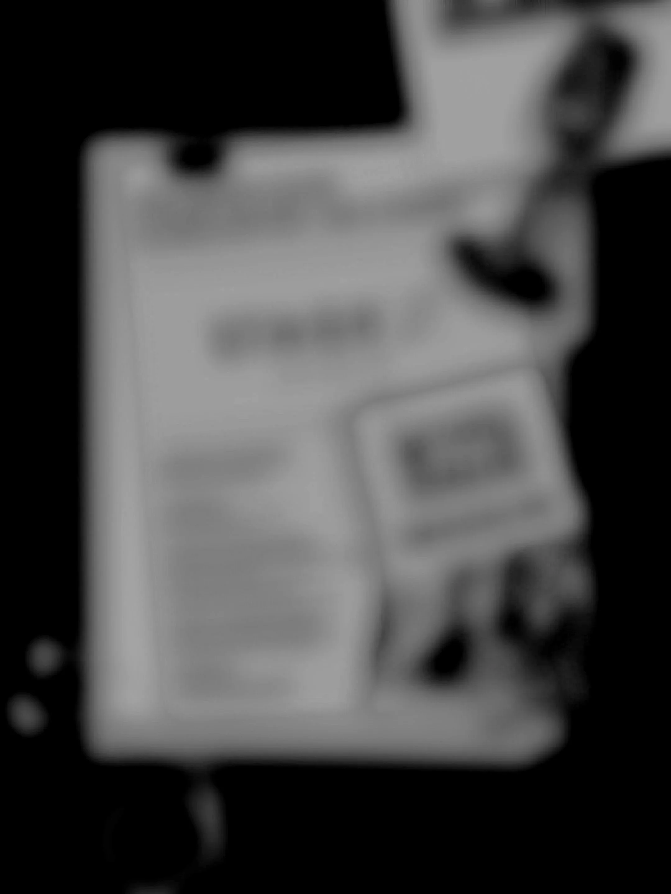 A blurry close-up of a colorful box or packaging with some black and pink elements visible on the right side.