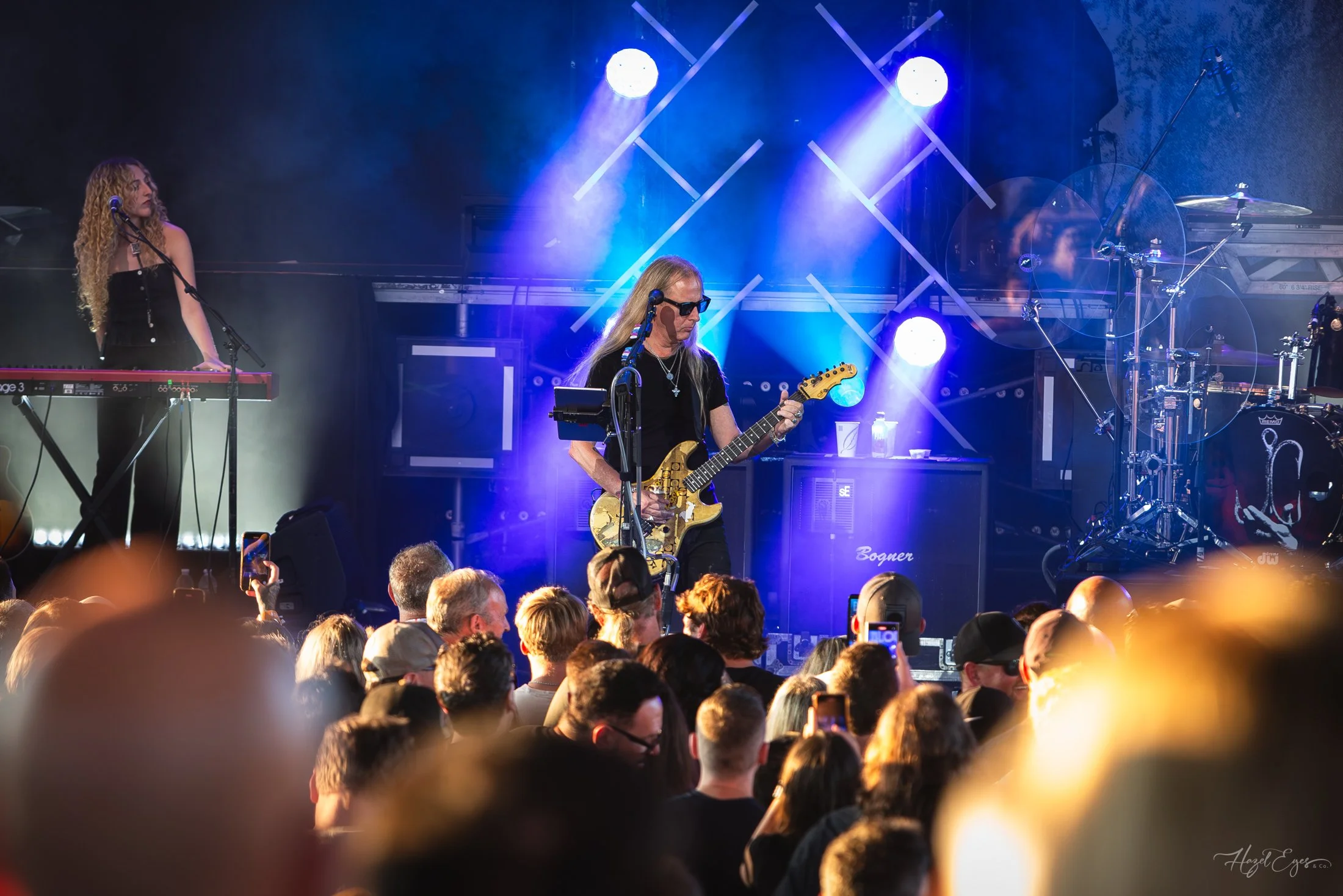 Jerry Cantrell in concert at Michigan Lottery Amphitheatre at Freedom Hill in Sterling Heights, MI on August 16, 2024. Guitarist on stage backlit with bright stage lighting with audience in foreground.